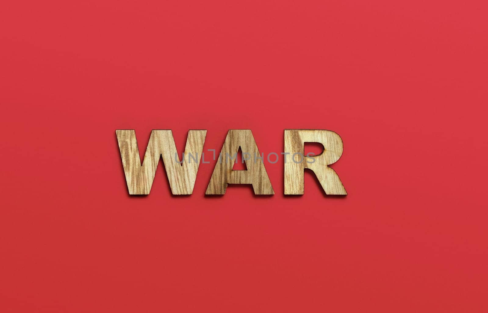 WAR, word written in wooden alphabet letters on red background. The concept of a terrible war destroying country. Top view. Copy space