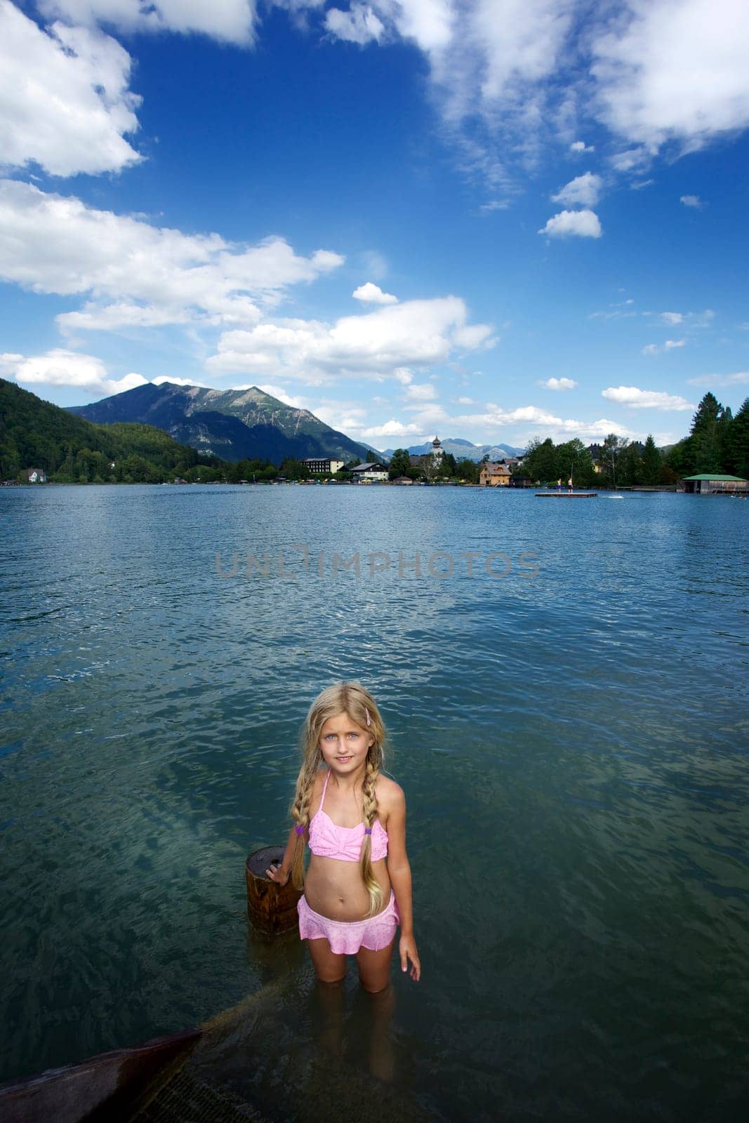 Little blonde girl swimming in the lake