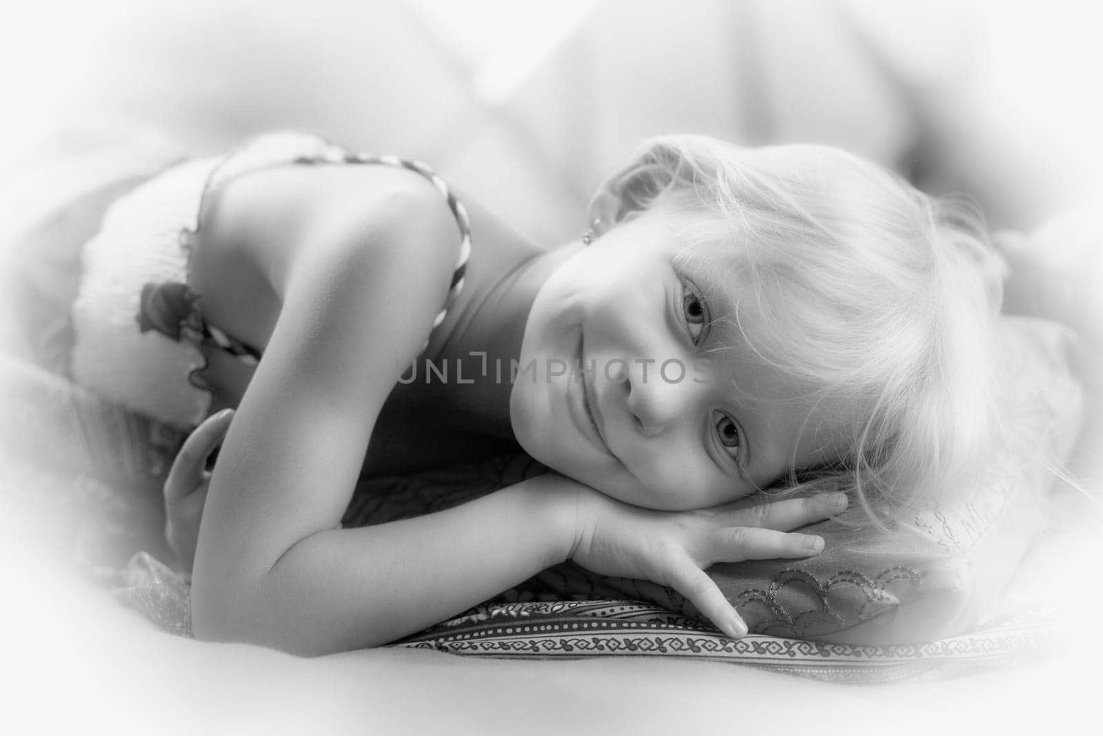 Portrait of a little girl lying on a pillow