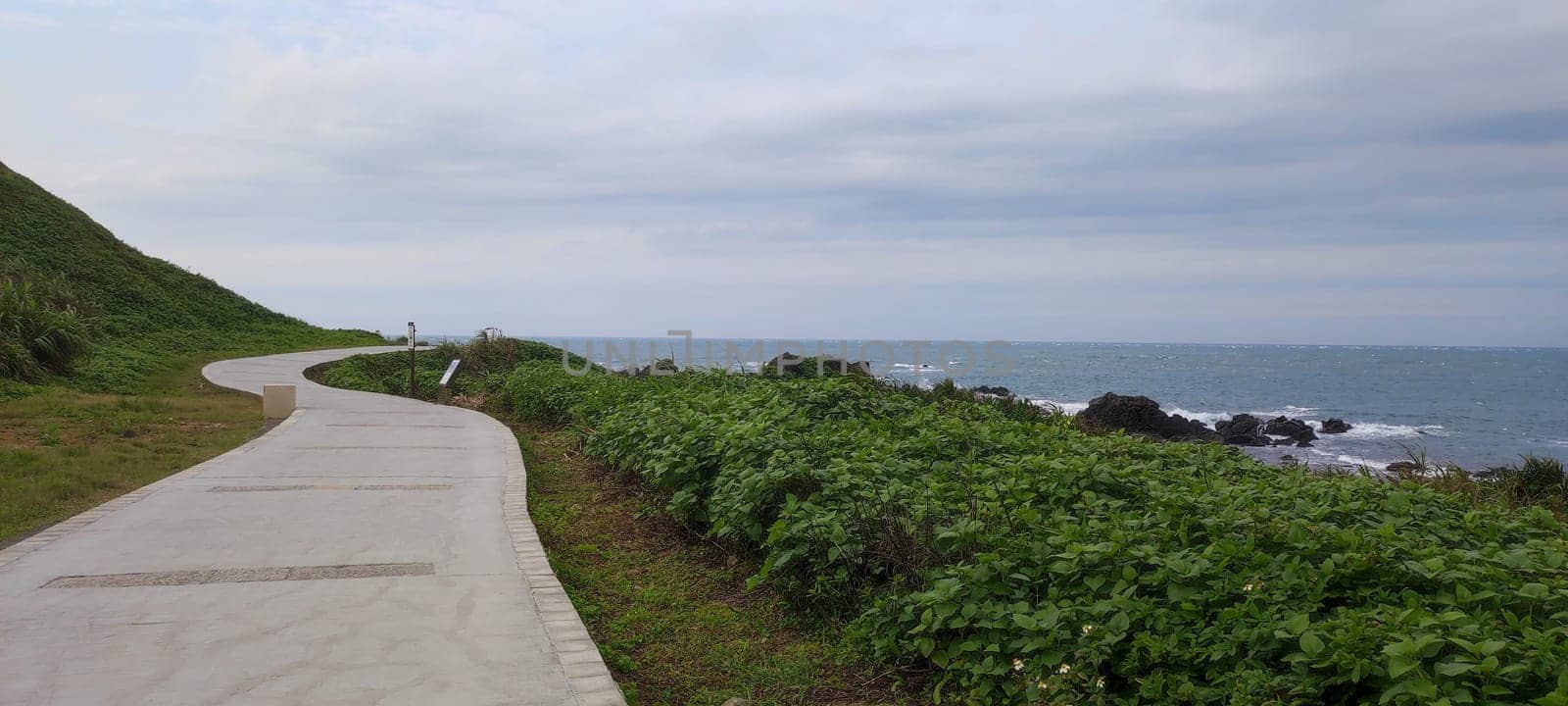 The Sea harbor with blue sky and green meadow.