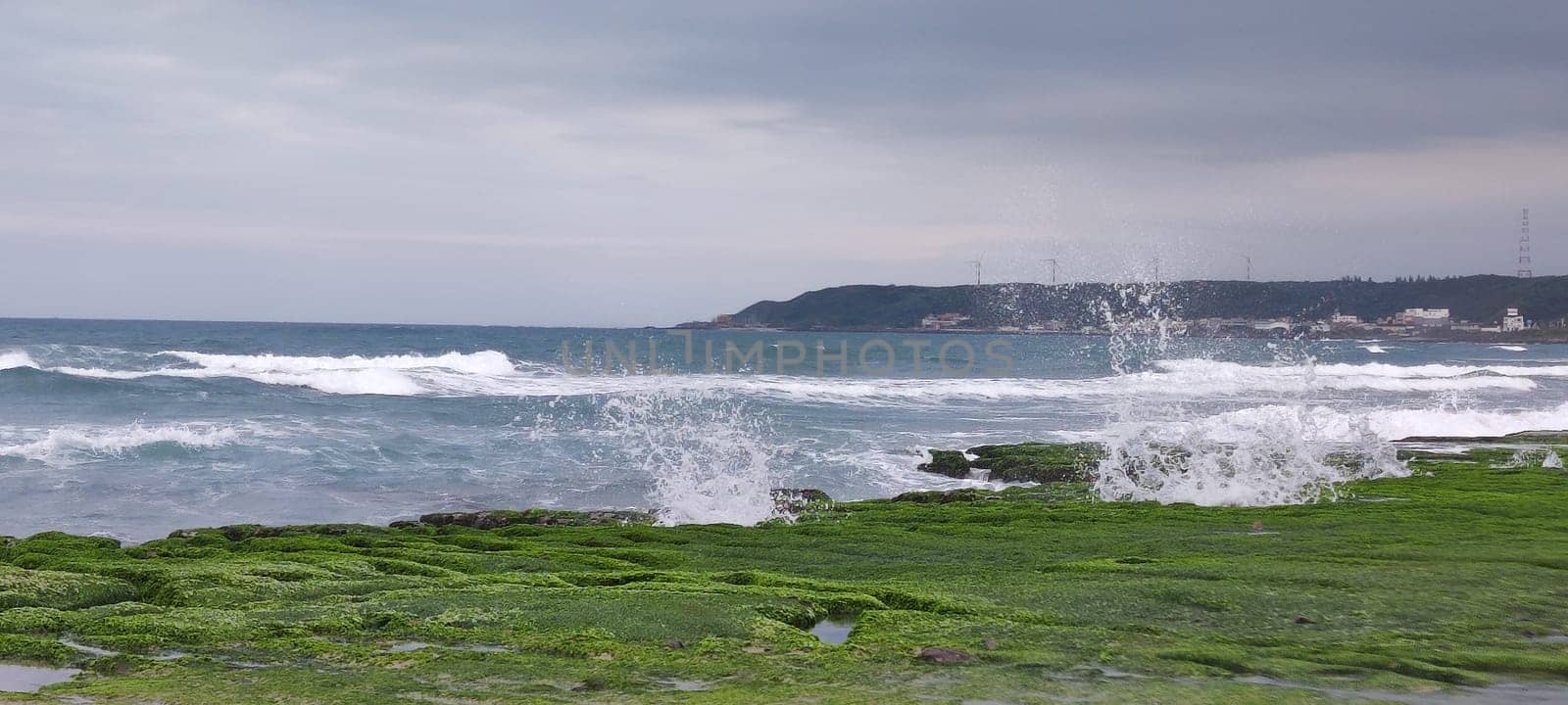 The Laomei Green Stone Trough is located in Shimen District on the North Coast, Every April and May, because the northeast monsoon slowly weakens, the local rock trough scientific name: tidal trench and sea erosion trench is covered with a large green seaweed