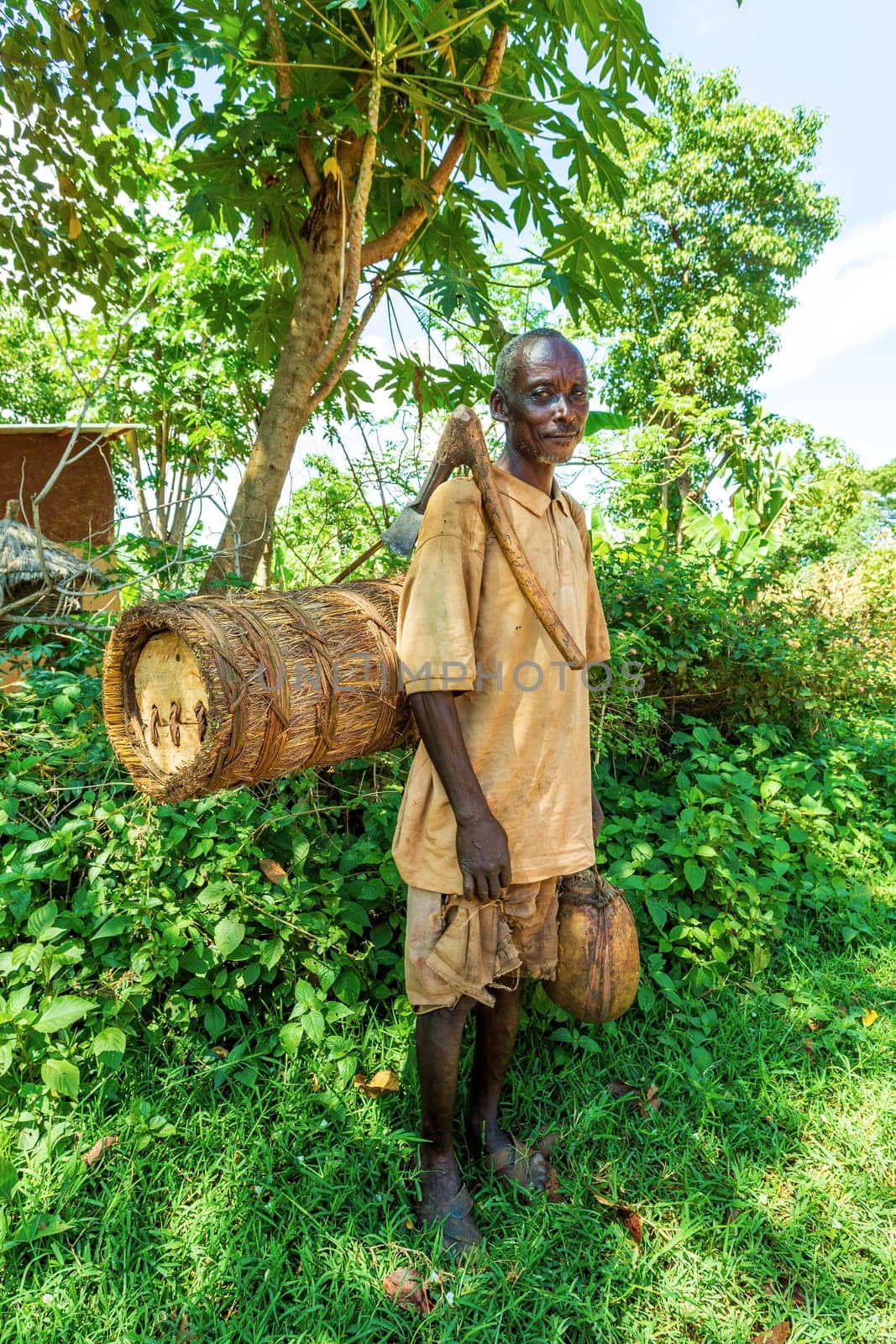Southern Nations, Ethiopia - May 10, 2019: Unknown poor Ethiopian farmer with a bee hive and an primitive ax on his back in May 10. 2019 in Southern Nations , Ethiopia