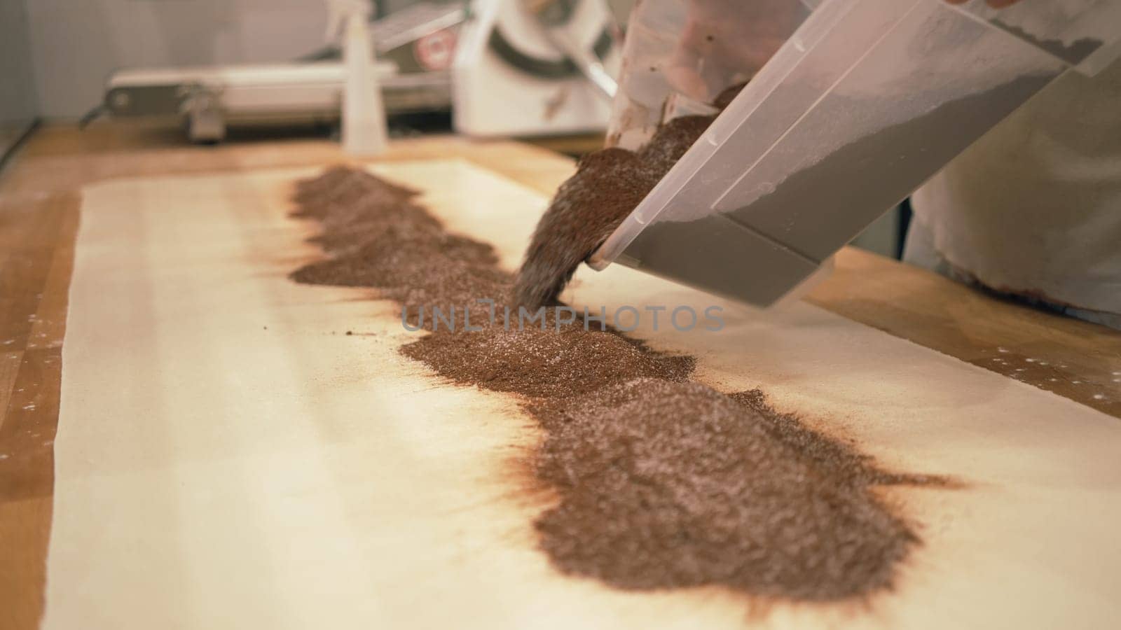 Baker working with handmade pastries in small bakery. Cocoa snail roll, chocolate roll. Closeup photo of not staged, authentic moment.