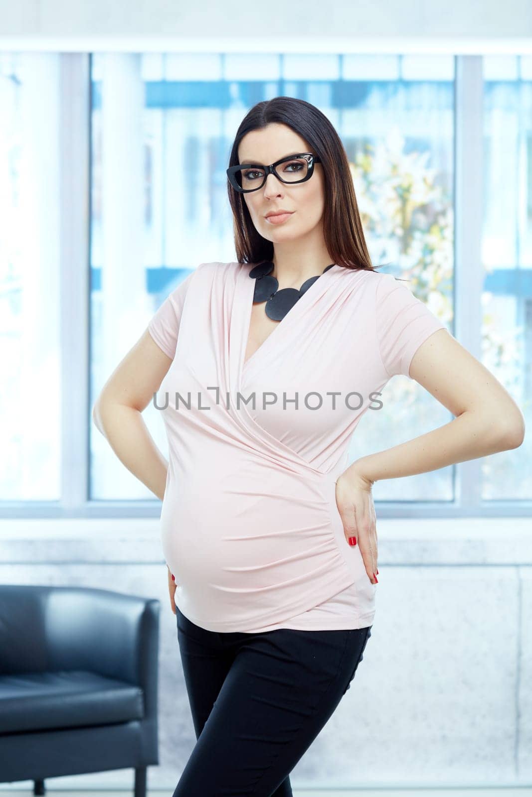 Today women working during pregnancy - Serious pregnant woman working in modern business office.