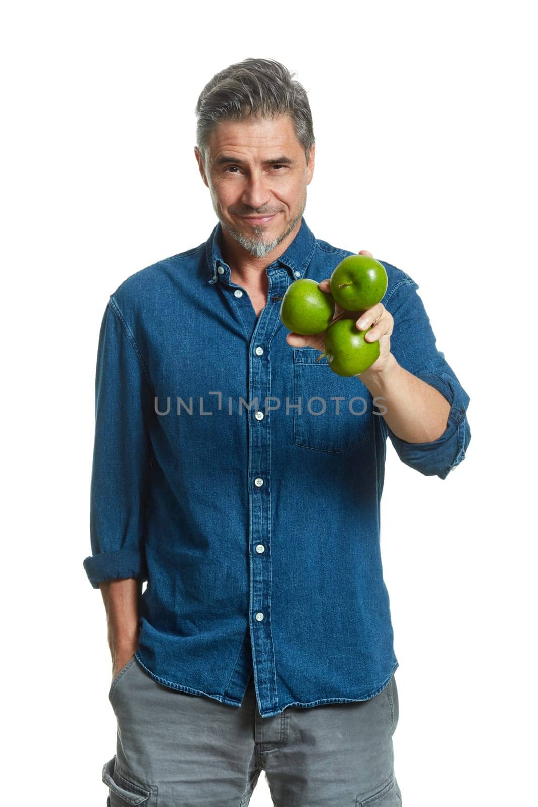 Casual older white man man holding green apple - healthy eating.