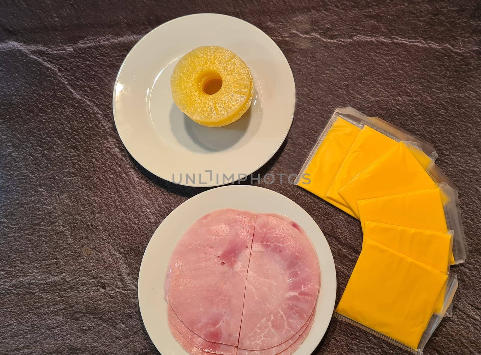 Hawaiian toast with ham, cheese and pineapple on a cutting board on a dark background, horizontal