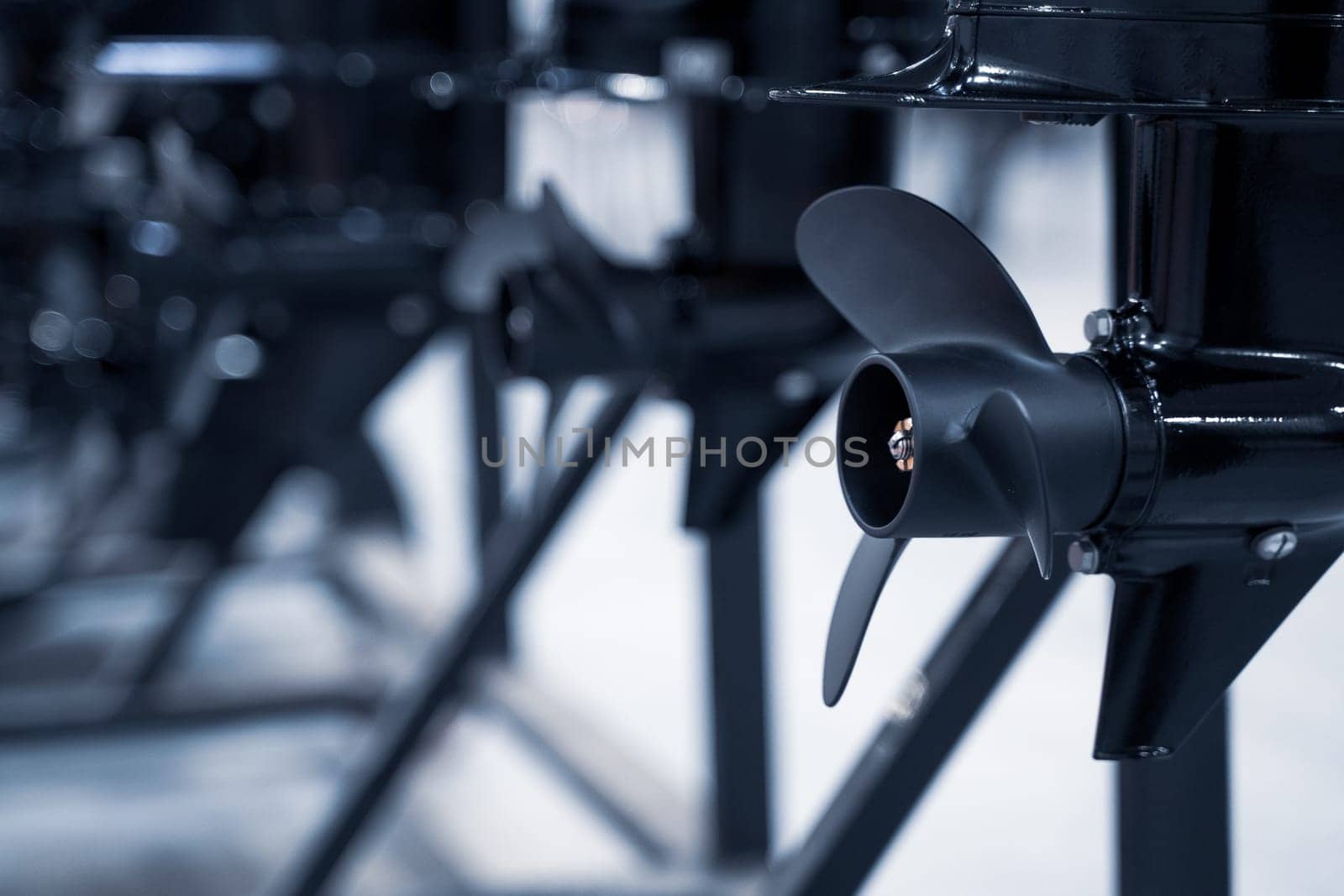 perspective view closeup of row of black boat ship propellers