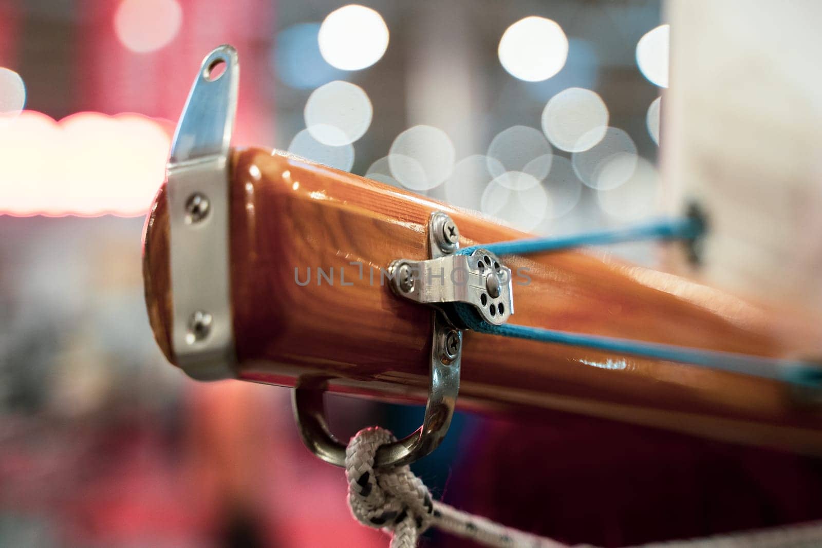 closeup perspective view of the boom mast of a vintage wooden sailing yacht with main sheet rope knot