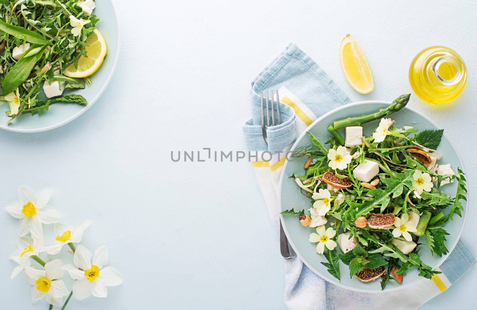 Spring salad with dandelion, asparagus, wild garlic, flowers, nettle and cream cheese. Healthy spring detox food background.