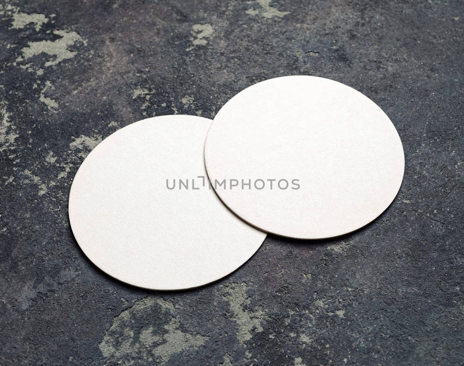Photo of two blank beer coasters on concrete background. For design presentations and portfolios.
