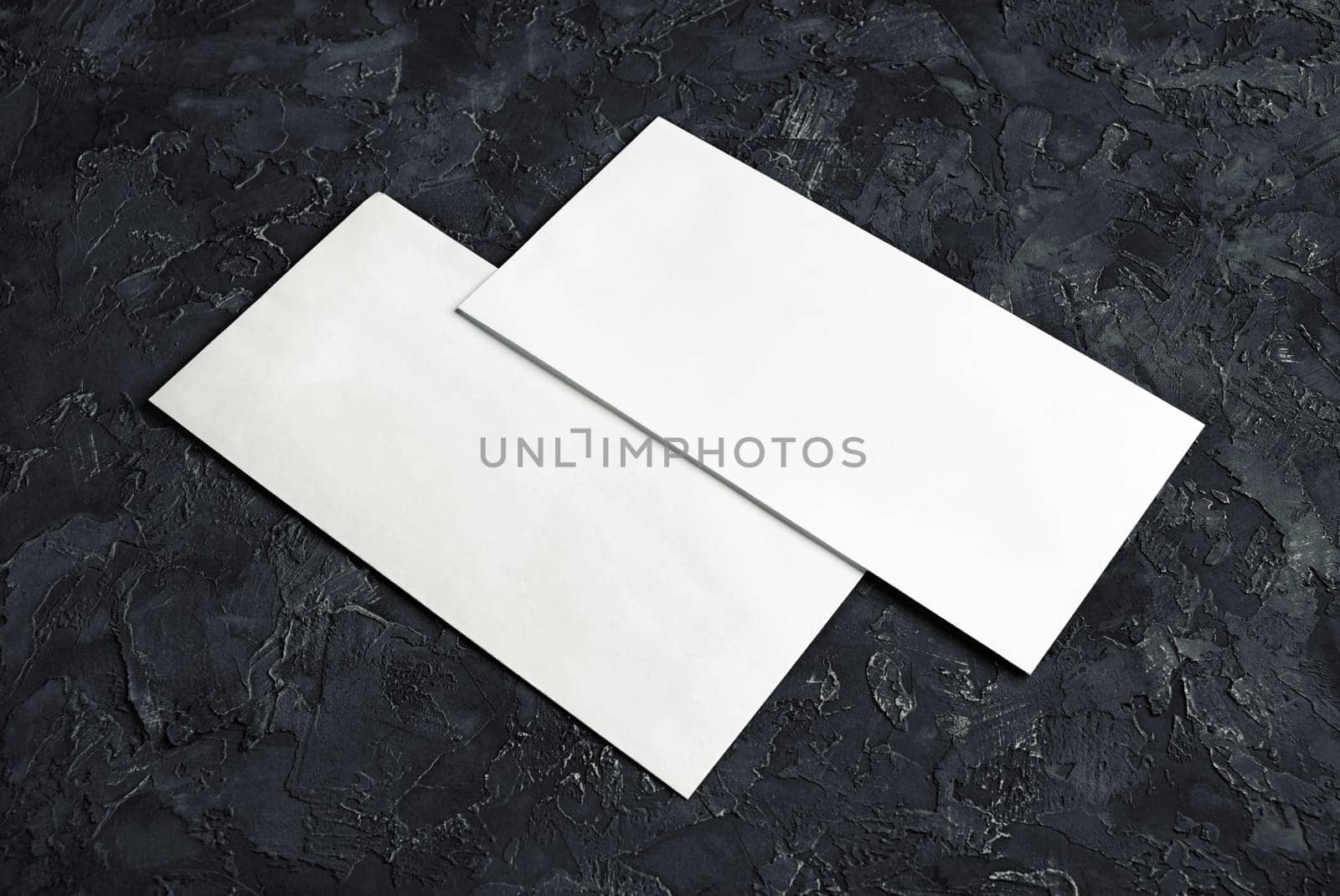 Blank paper envelopes on black plaster background. Template for your design.