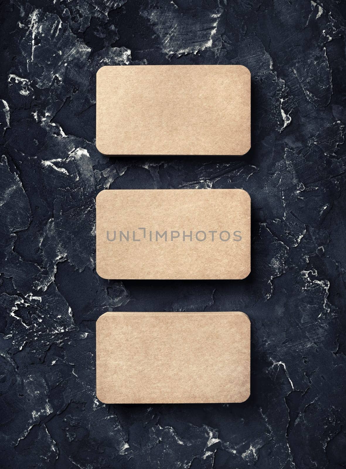 Photo of blank vintage business cards on black plaster background. Mockup for ID. Top view.