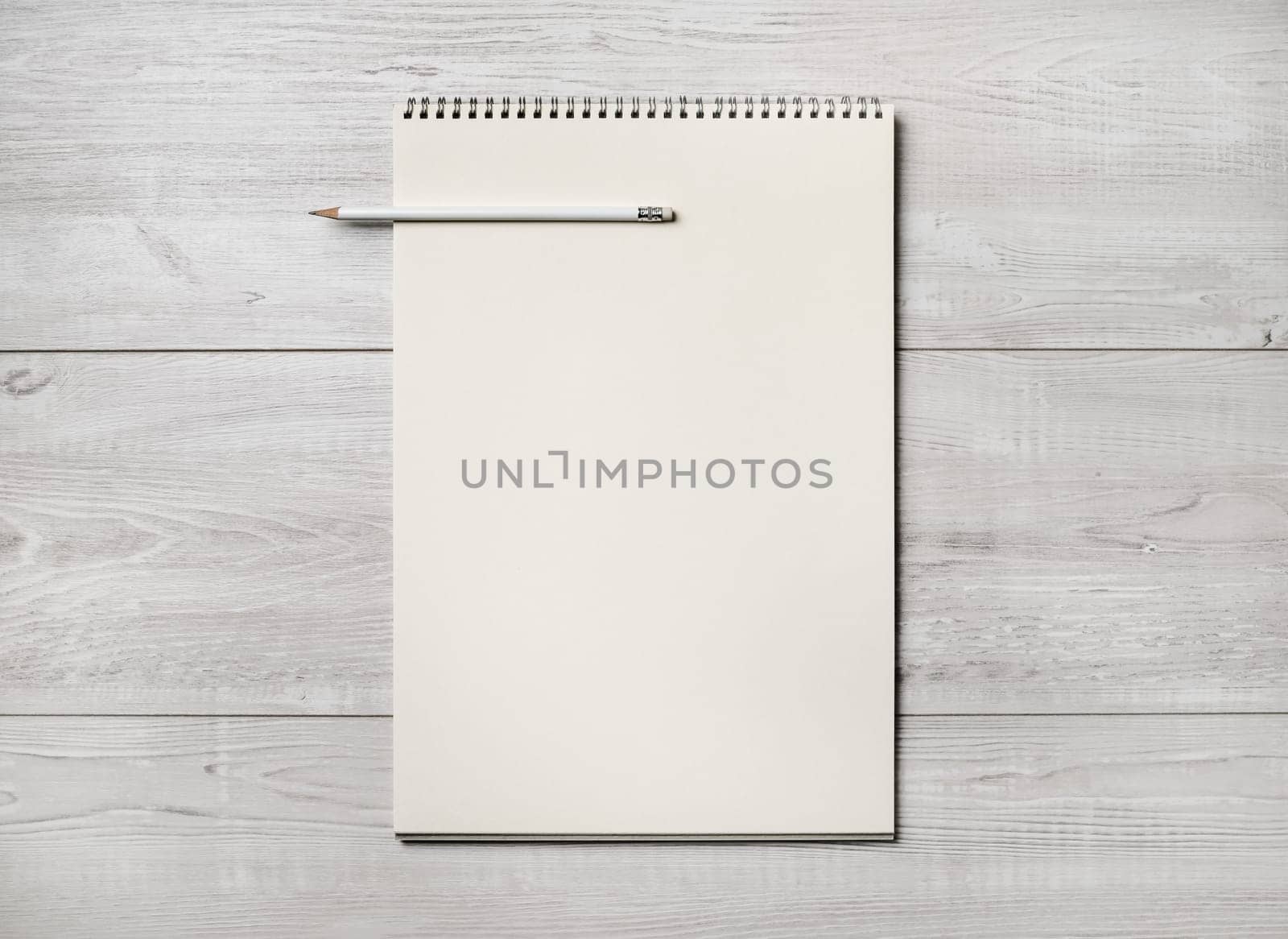 Photo of blank notepad and pencil on light wooden background. Responsive design template. Flat lay.