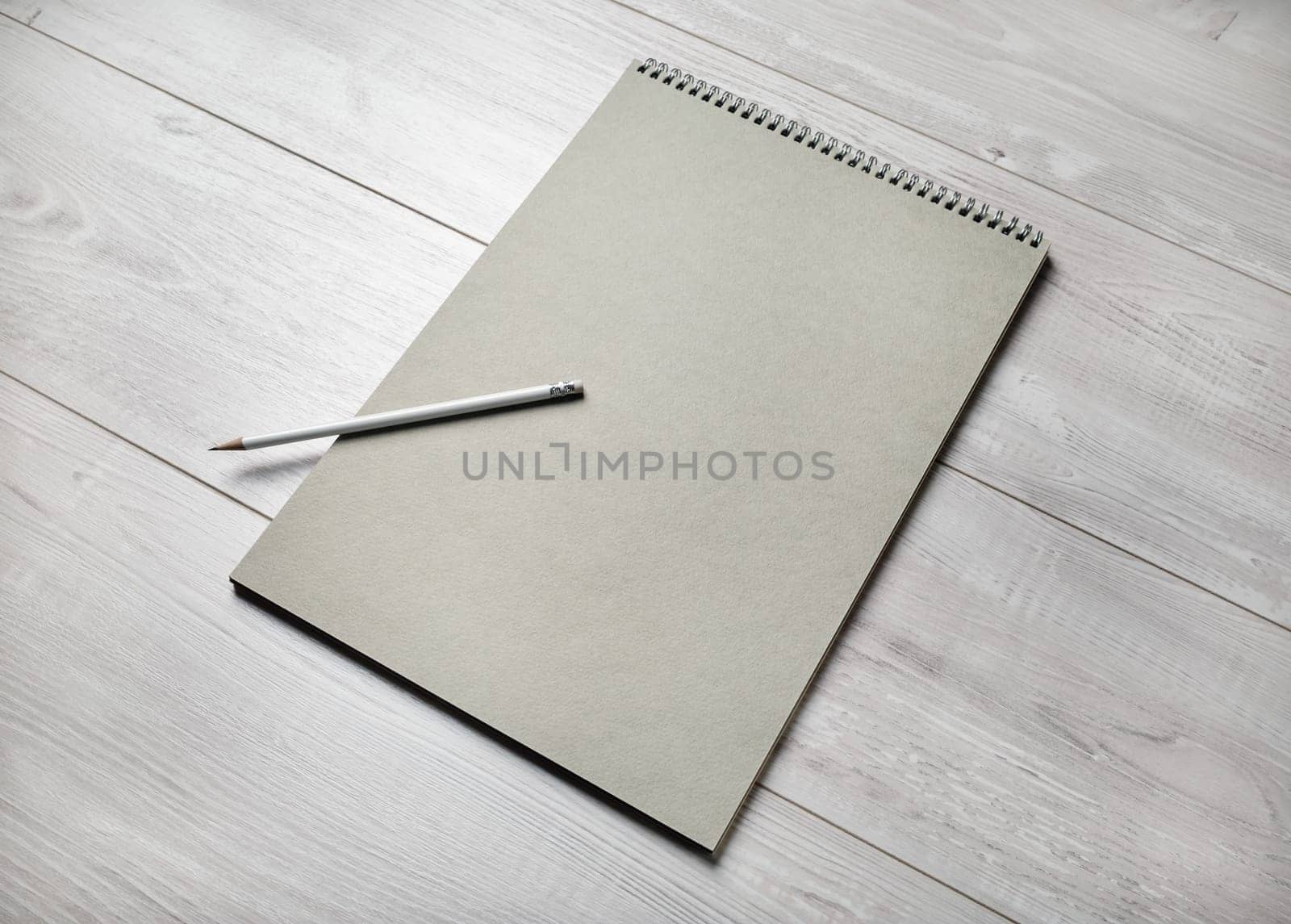 Photo of blank sketchbook and pencil on light wooden background. Responsive design template.
