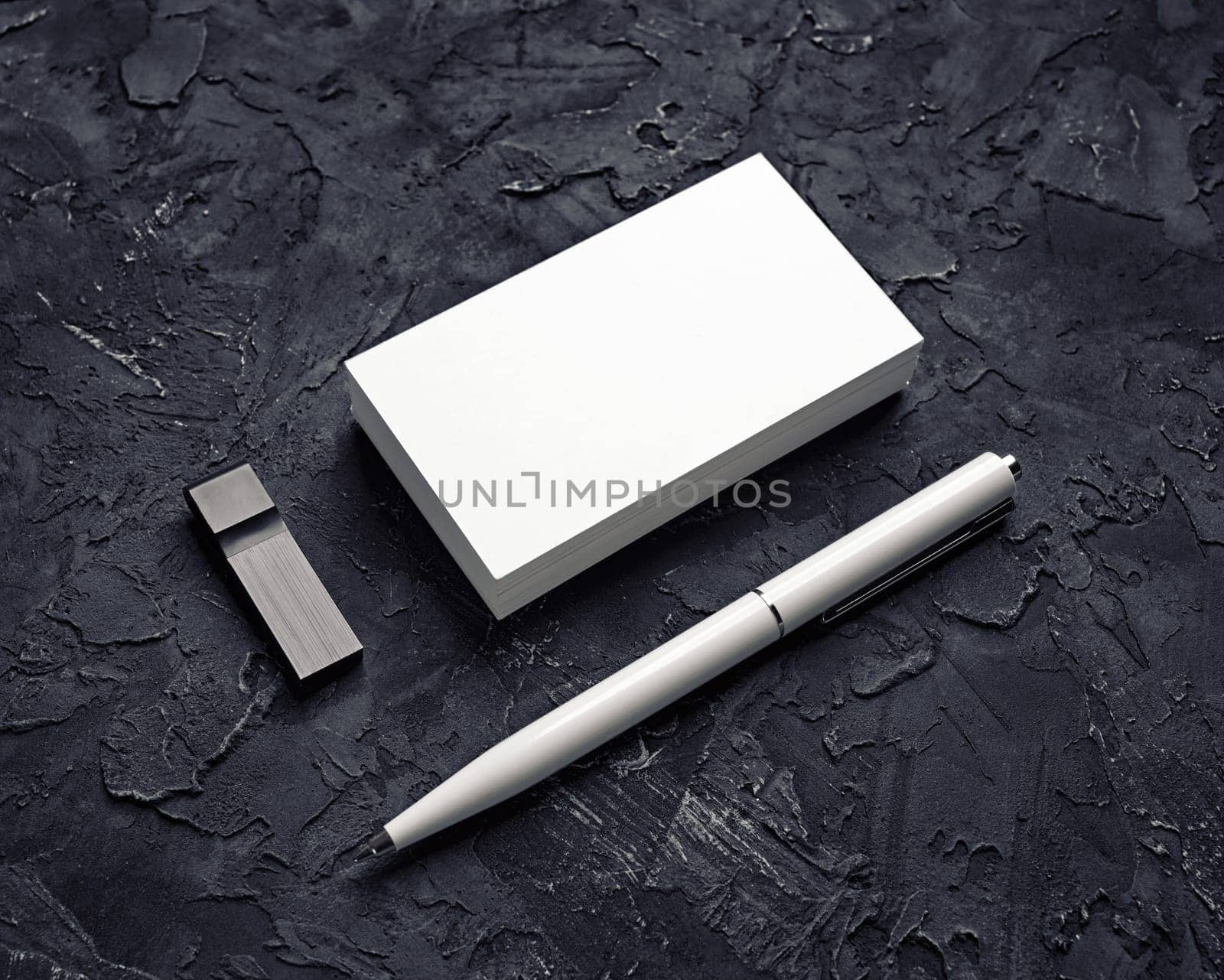 Blank business card, usb flash drive and pen on black plaster background. Mockup for branding identity. Template for graphic designers portfolios.
