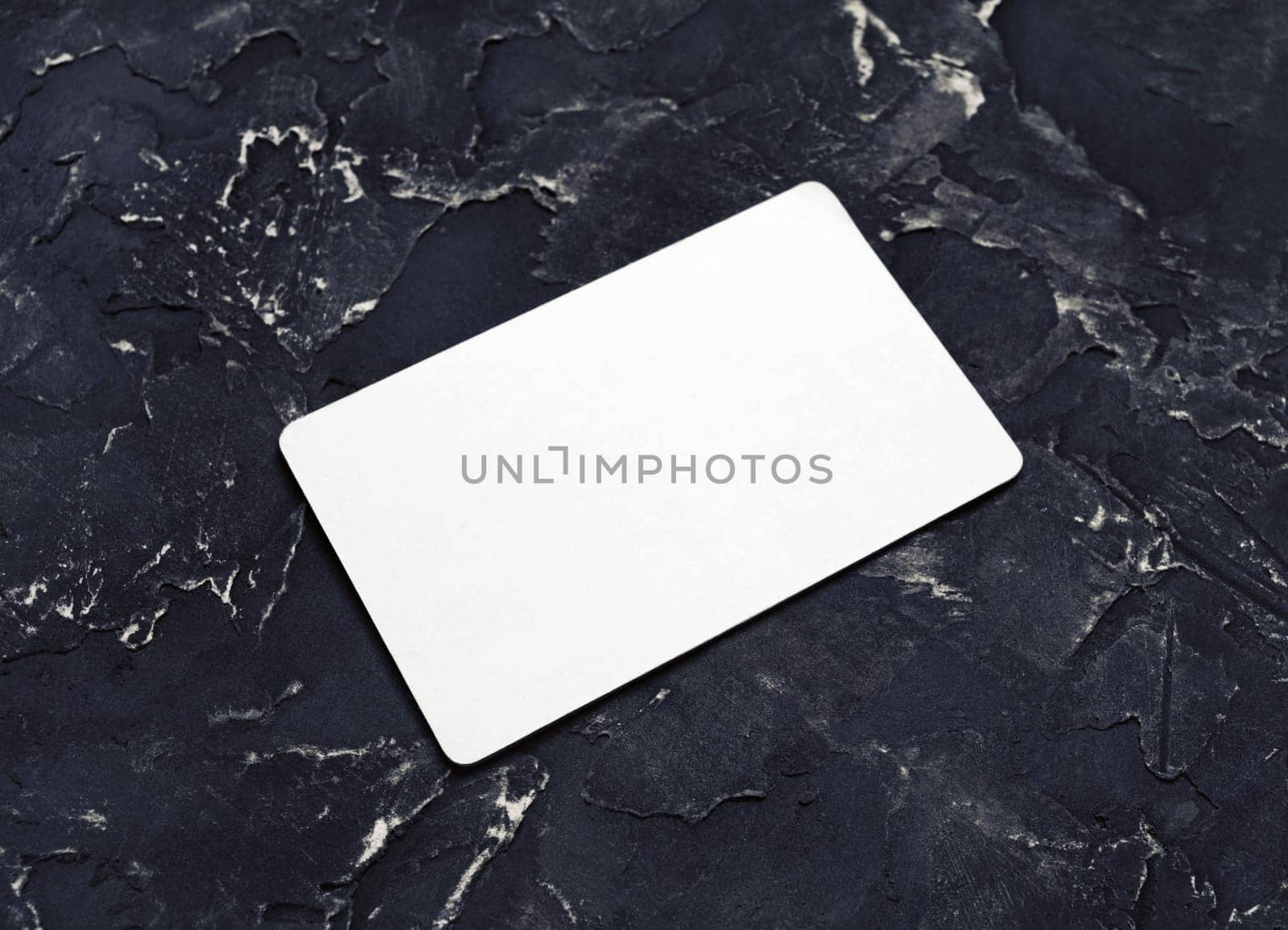 Blank business card mockup on black plaster background. Copy space for text.