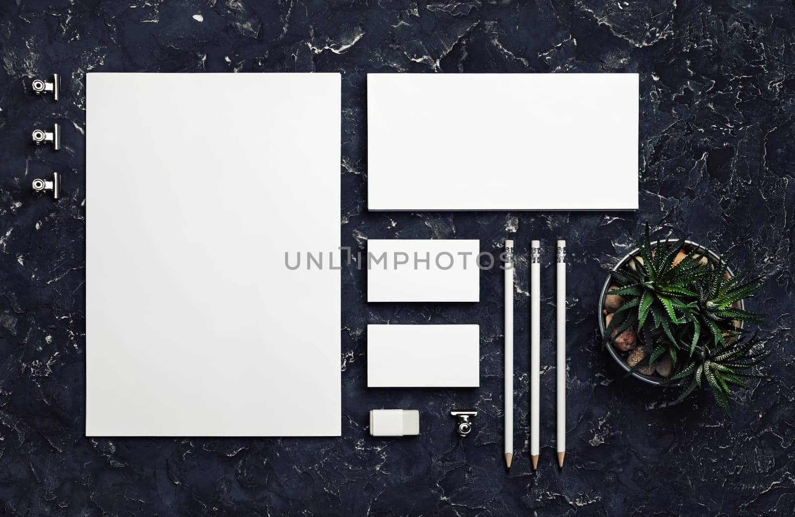 Photo of blank stationery set on black plaster background. Corporate identity mockup. Responsive design template. Top view. Flat lay.