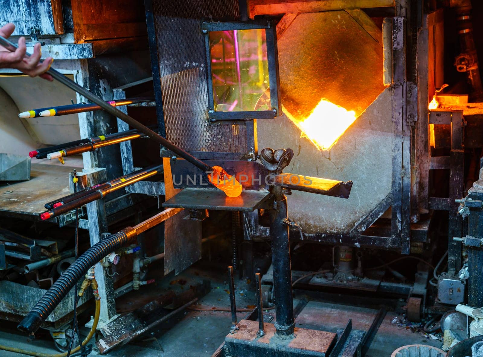 Shaping the hot glass gather during glassblowing process