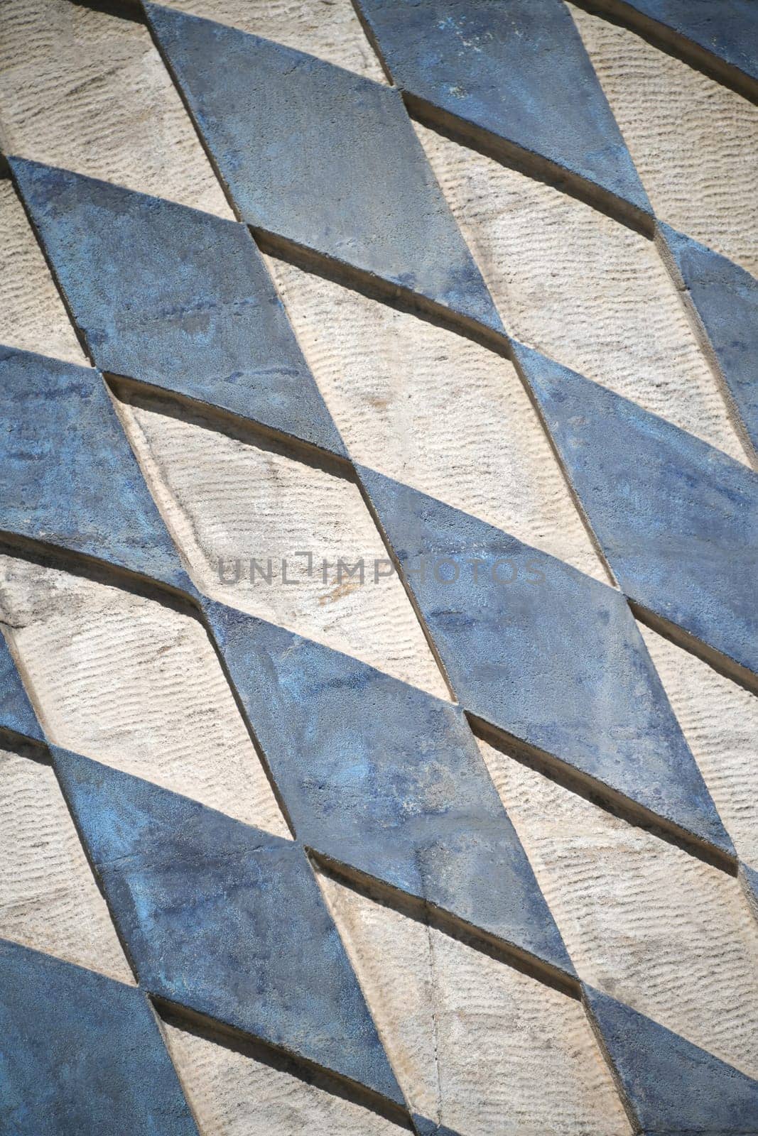 The Bavarian coat of arms in blue and white rhombuses in the Free State of Bavaria on a wall as a background. The surface is rough.