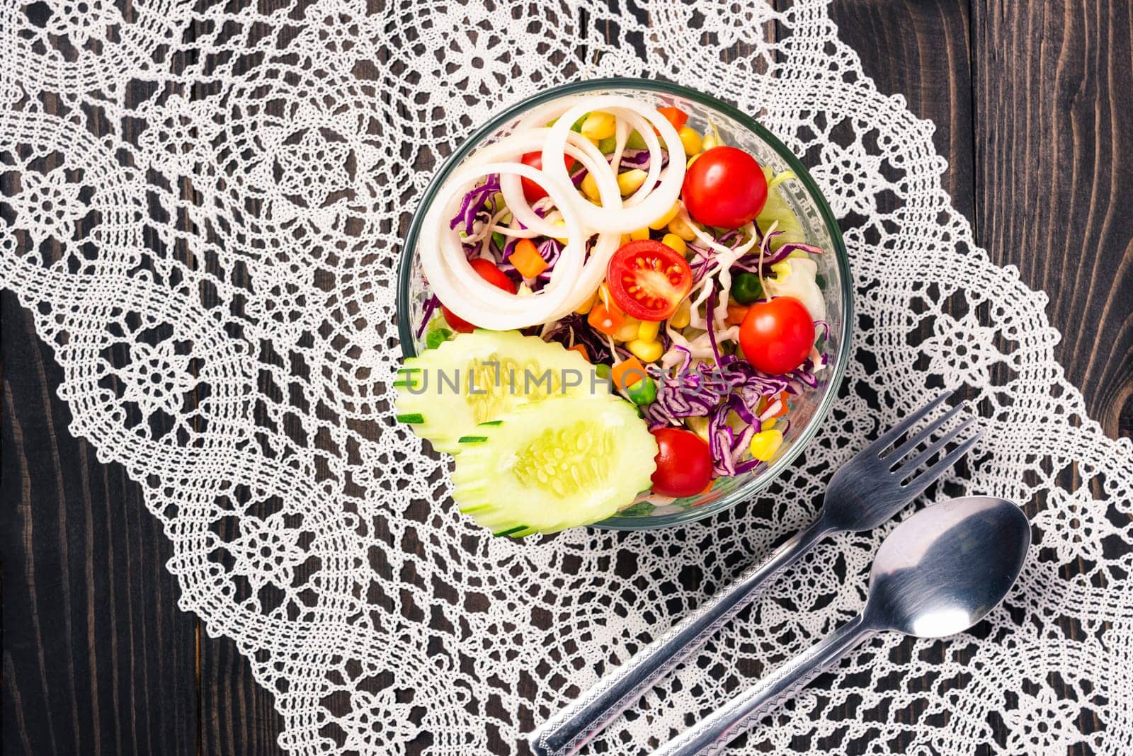 Top view of the healthy colorful fresh salad bowl with quinoa, tomatoes, and mixed greens vegetable in a dish on black wooden background, Health snack food
