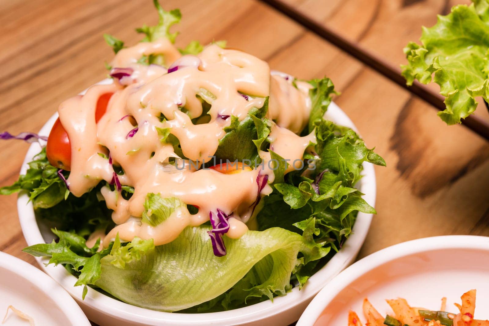 Spicy Kimchi. Korean pickle or Pickled radish vegetables and seasoning on bowl on wood table background, Japanese food
