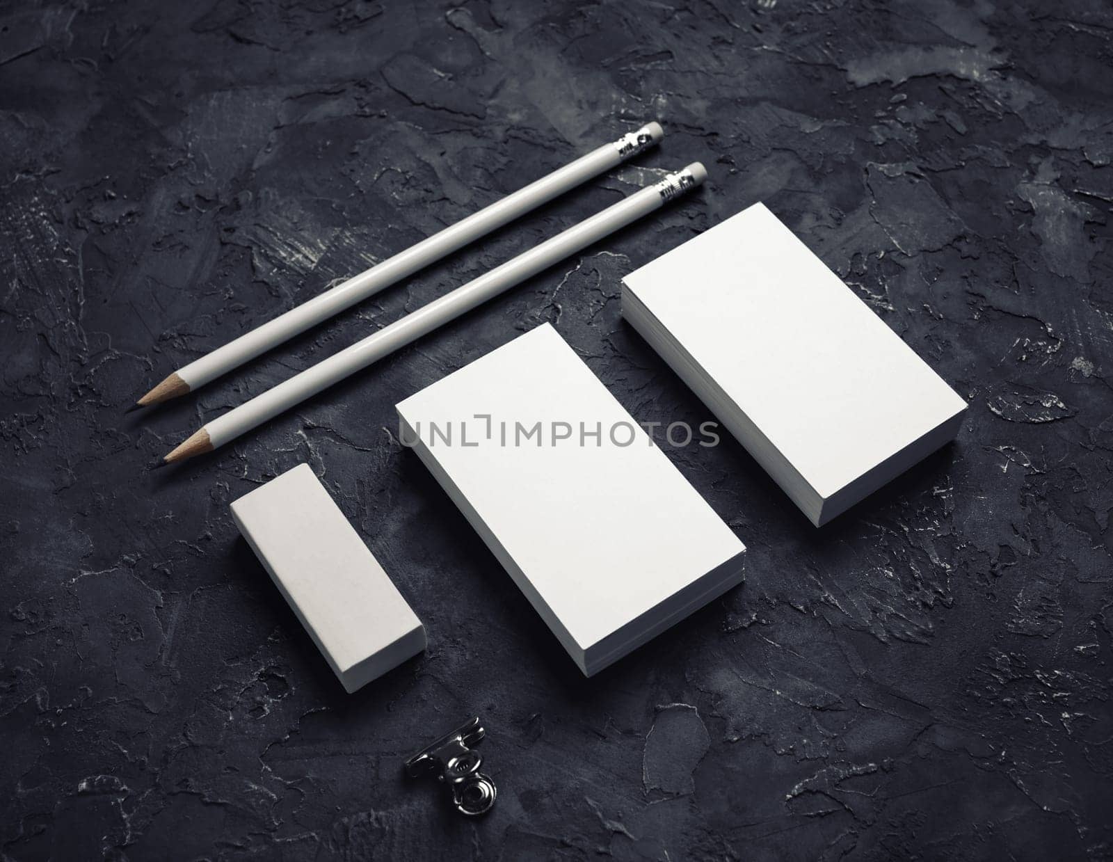Blank branding identity. Blank business card, pencils and eraser on black plaster background.