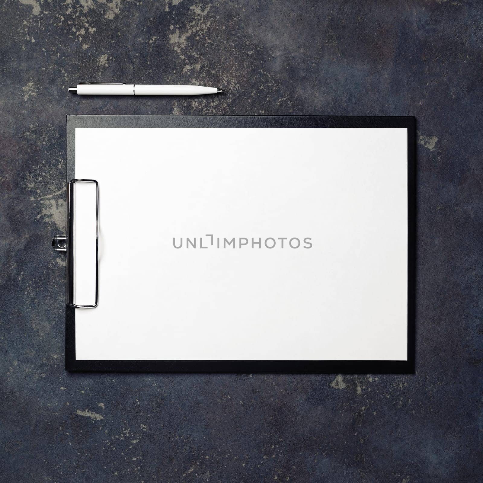 Clipboard with blank paper and pen on concrete background. Top view.