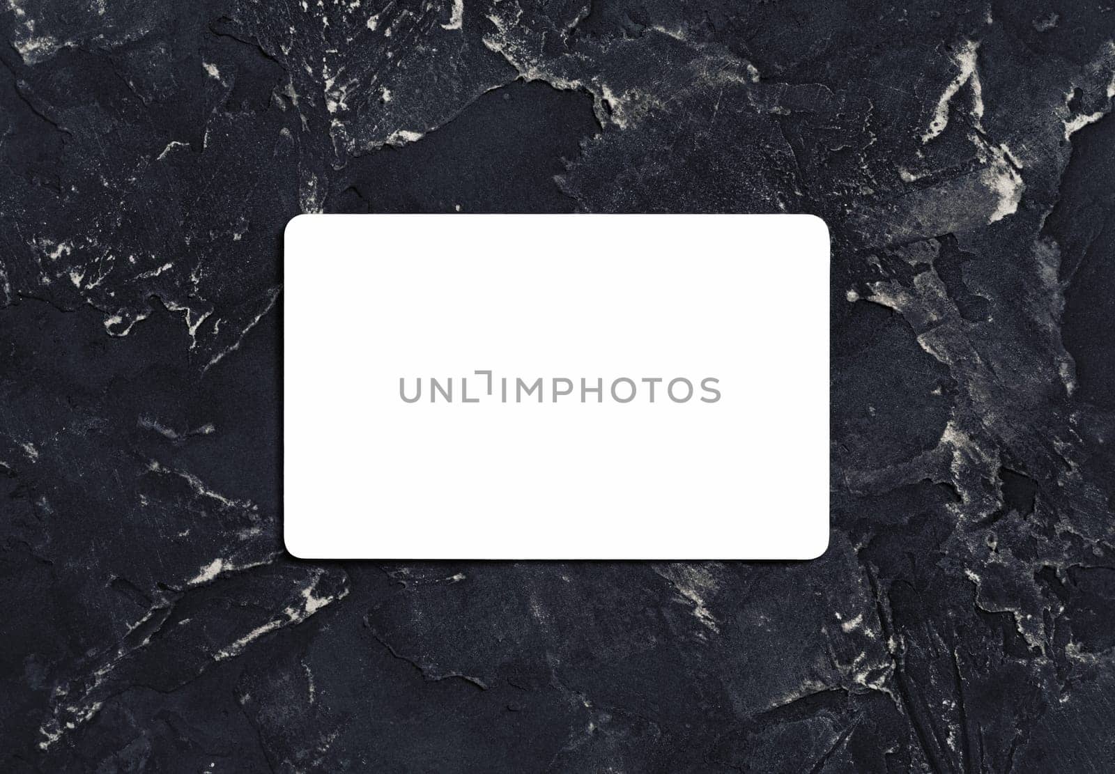 Blank white business card on black plaster background. Mockup for branding identity. Top view.