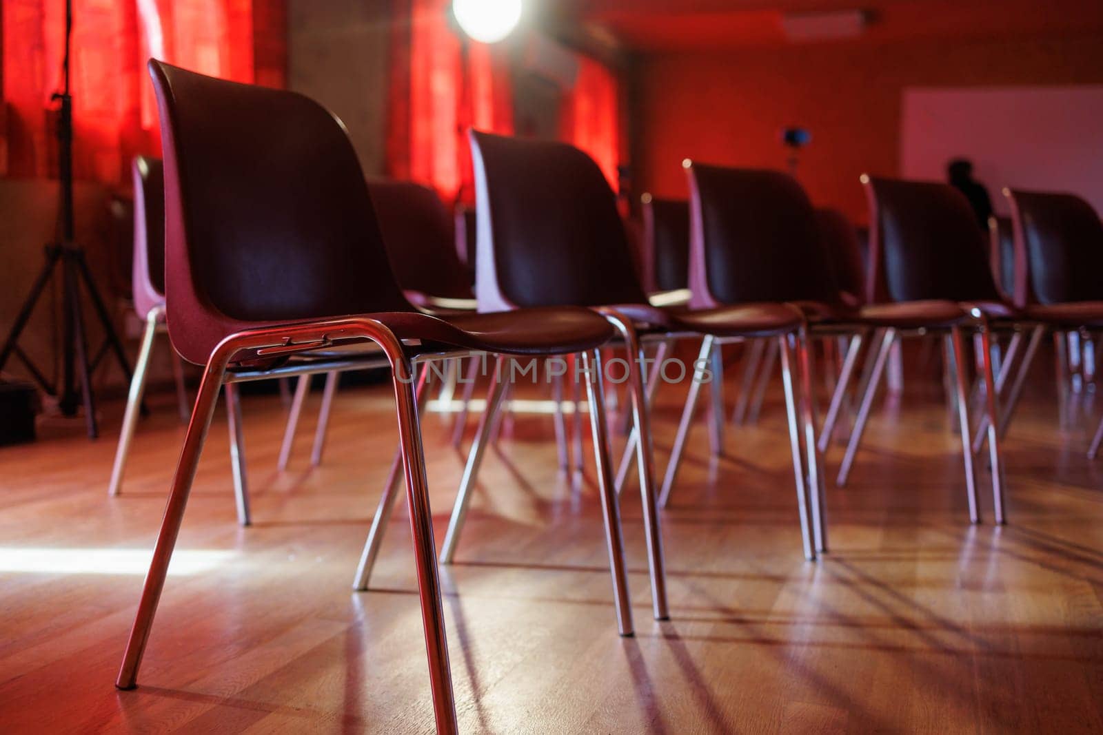 Many chairs in a room for an event with red ambiance
