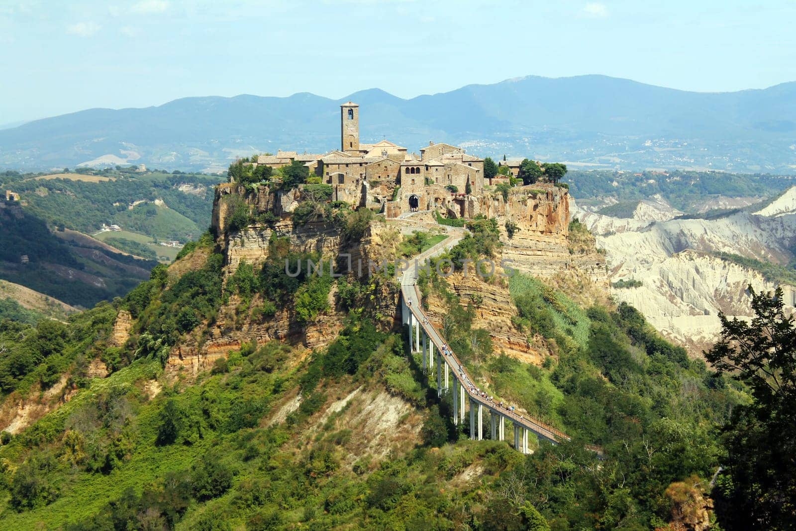 Close up of the historical civita village of Bagnoregio standing on a cliff with the long pedestrian bridge in the center of Italy