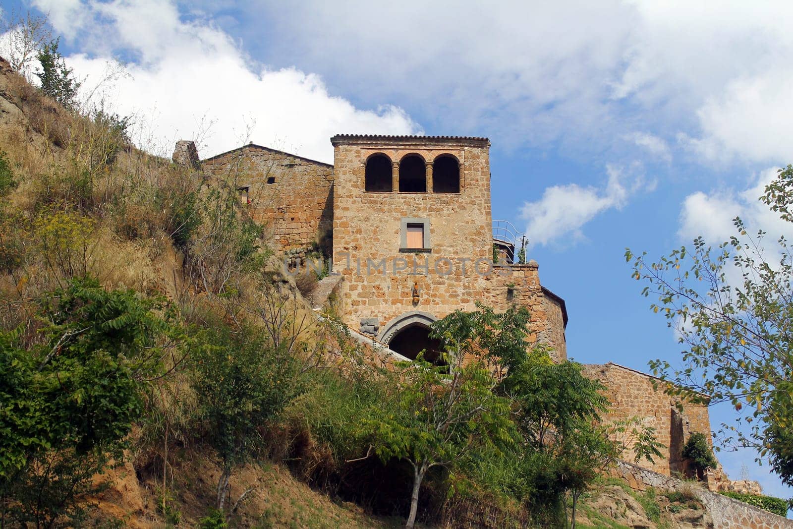A traditional rock house on the cliff of a mountain with olive trees in Umbria in Italy