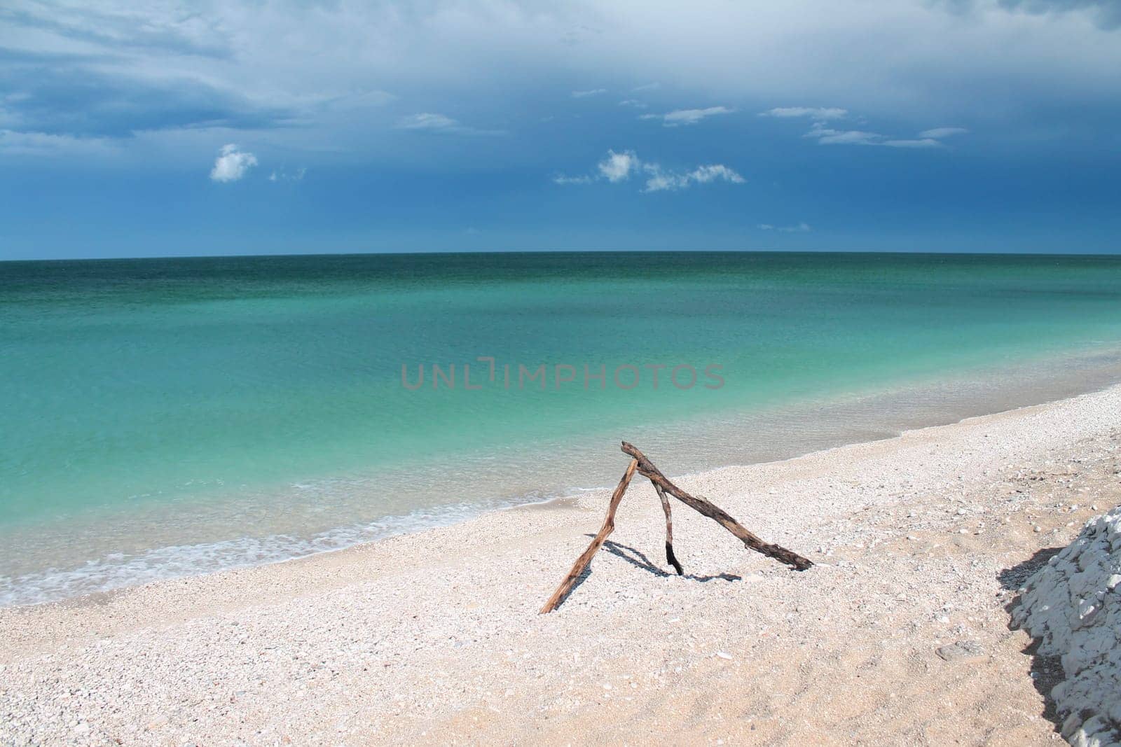 The pyramid pieces of wood on the white sand beach with turquoise Adriatic Sea in Conero in Italy