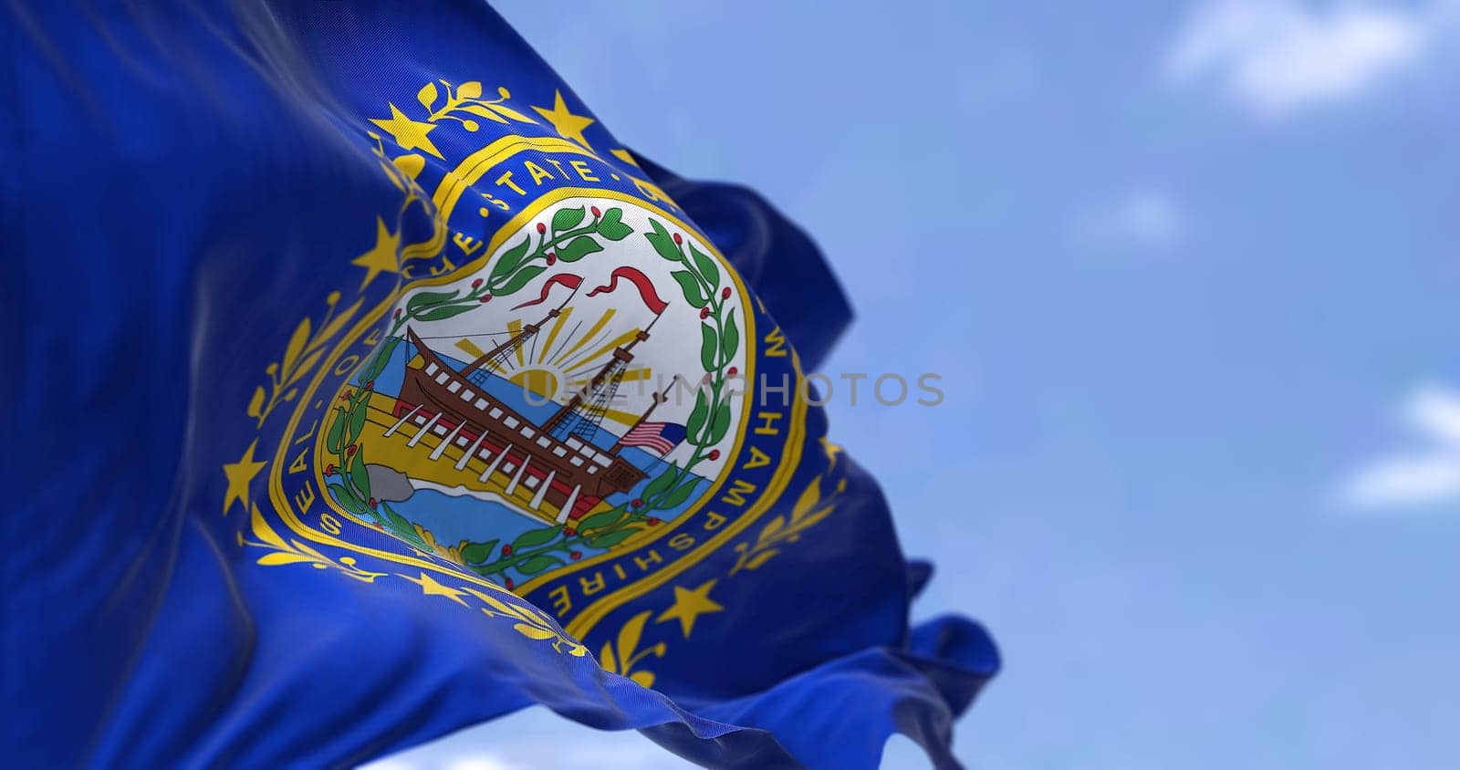 The US state flag of New Hampshire waving in the wind. New Hampshire is a state in the New England region of the United States. Democracy and independence.