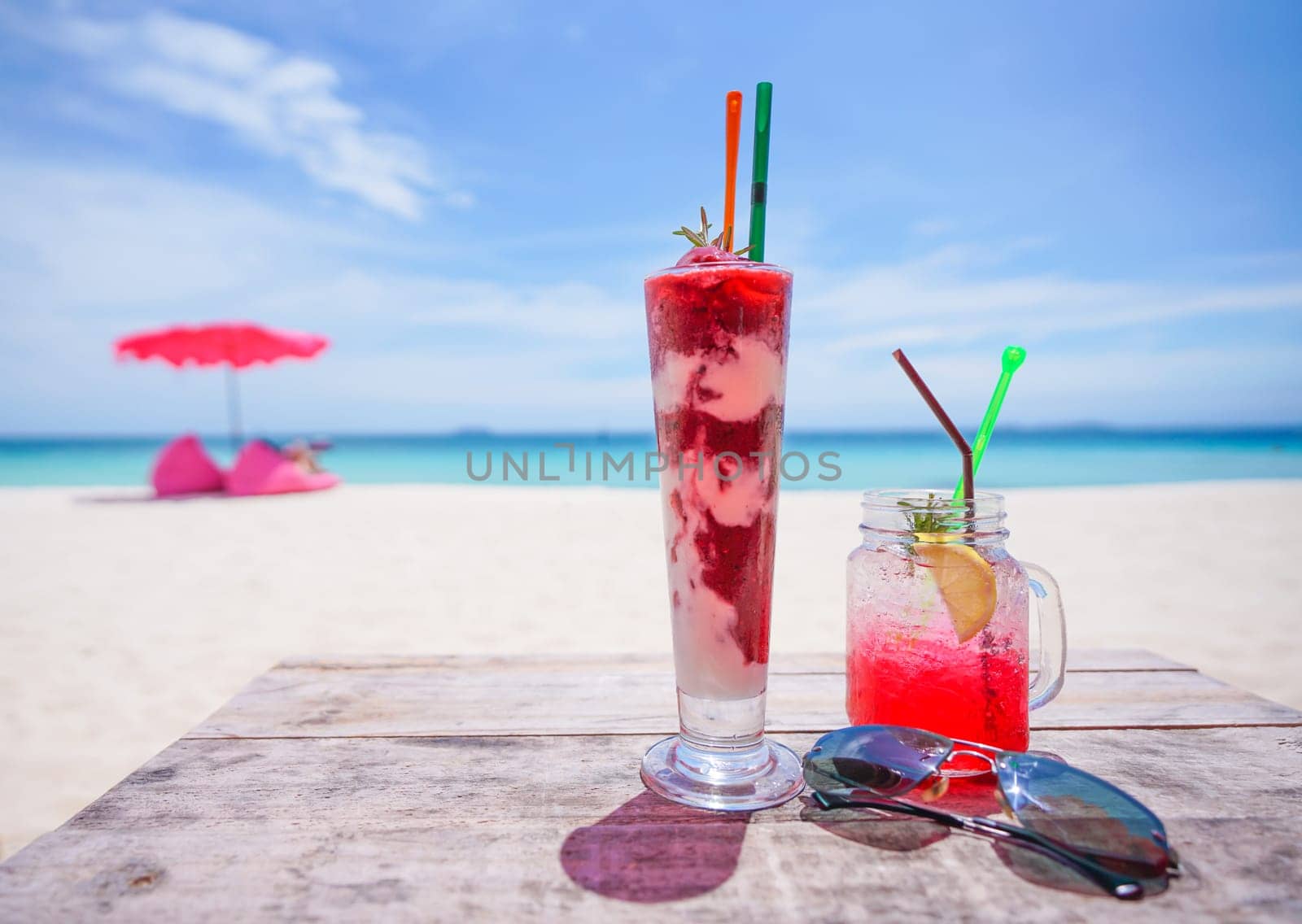 fresh cold drink on wooden table and  Summer blurred background of beach