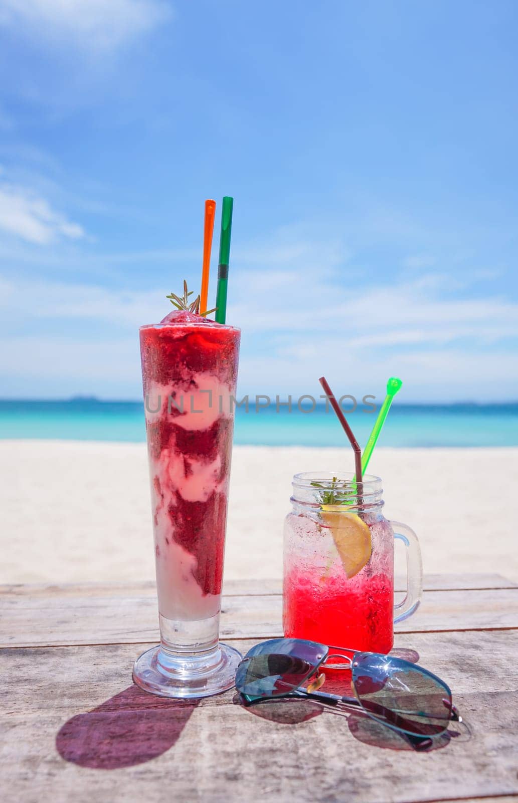 fresh cold drink on wooden table and  Summer blurred background of beach