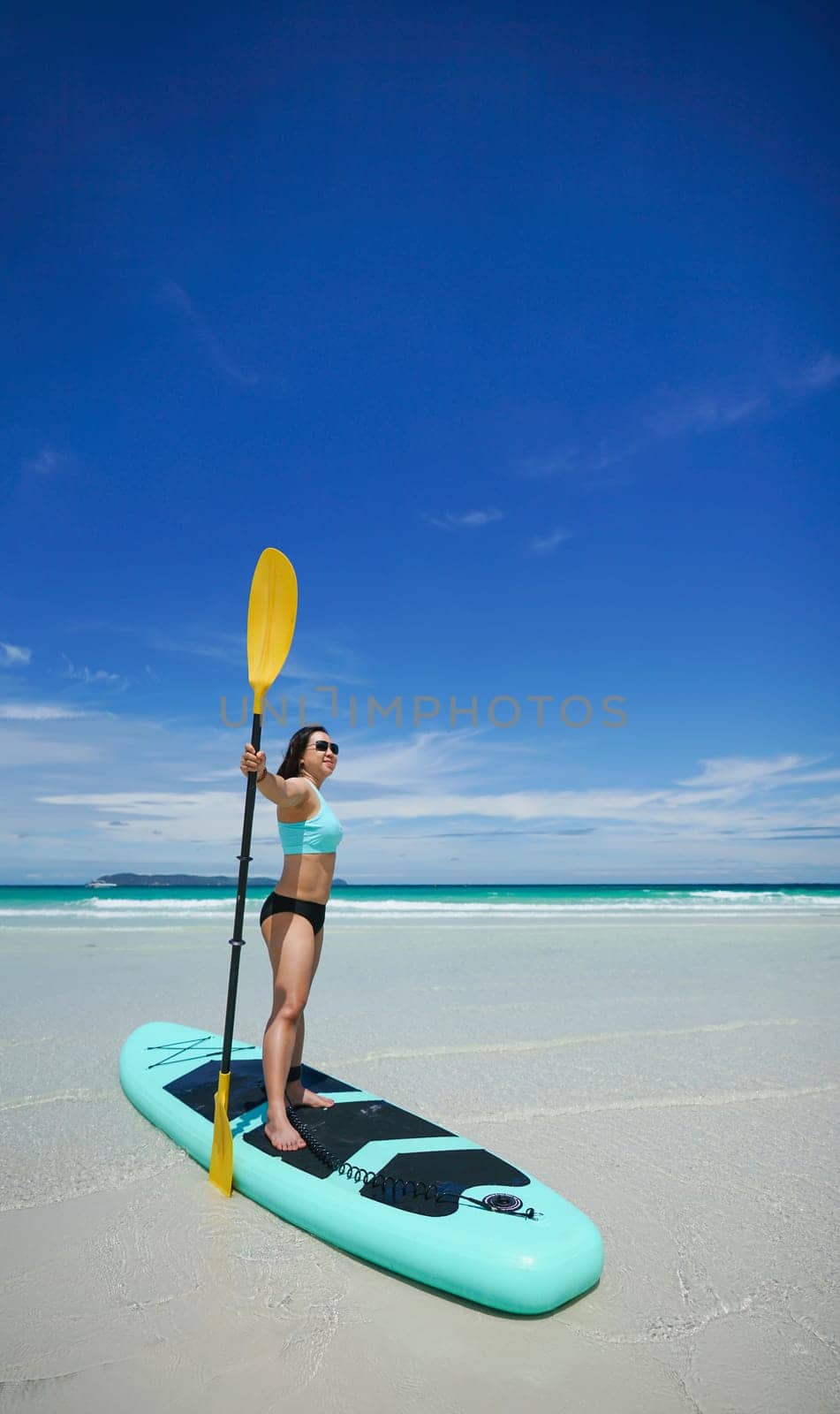 woman on sup board or paddle board at the beach