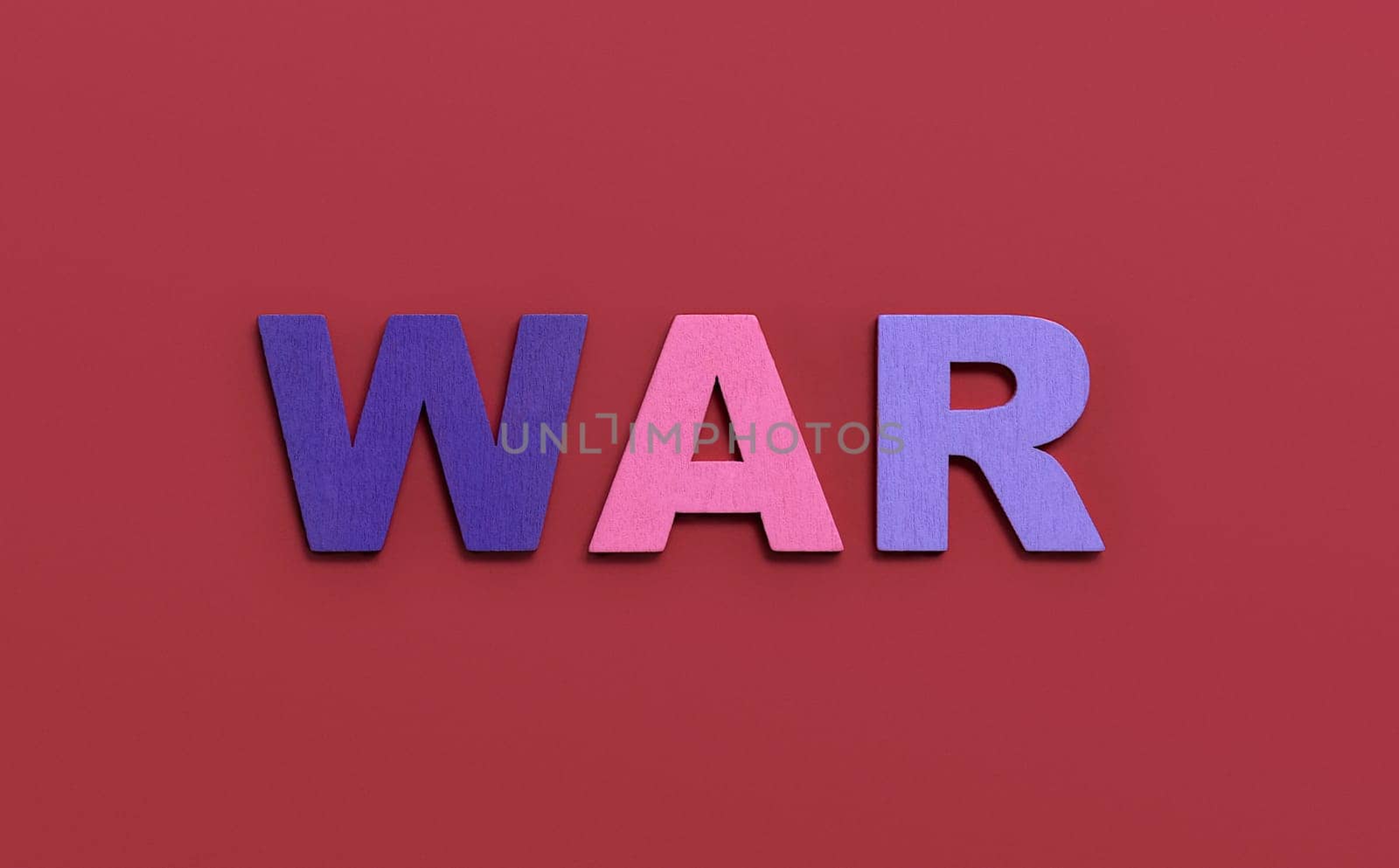 WAR, word written in colorful wooden alphabet letters on red background. The concept of a terrible war destroying country. Top view. Copy space
