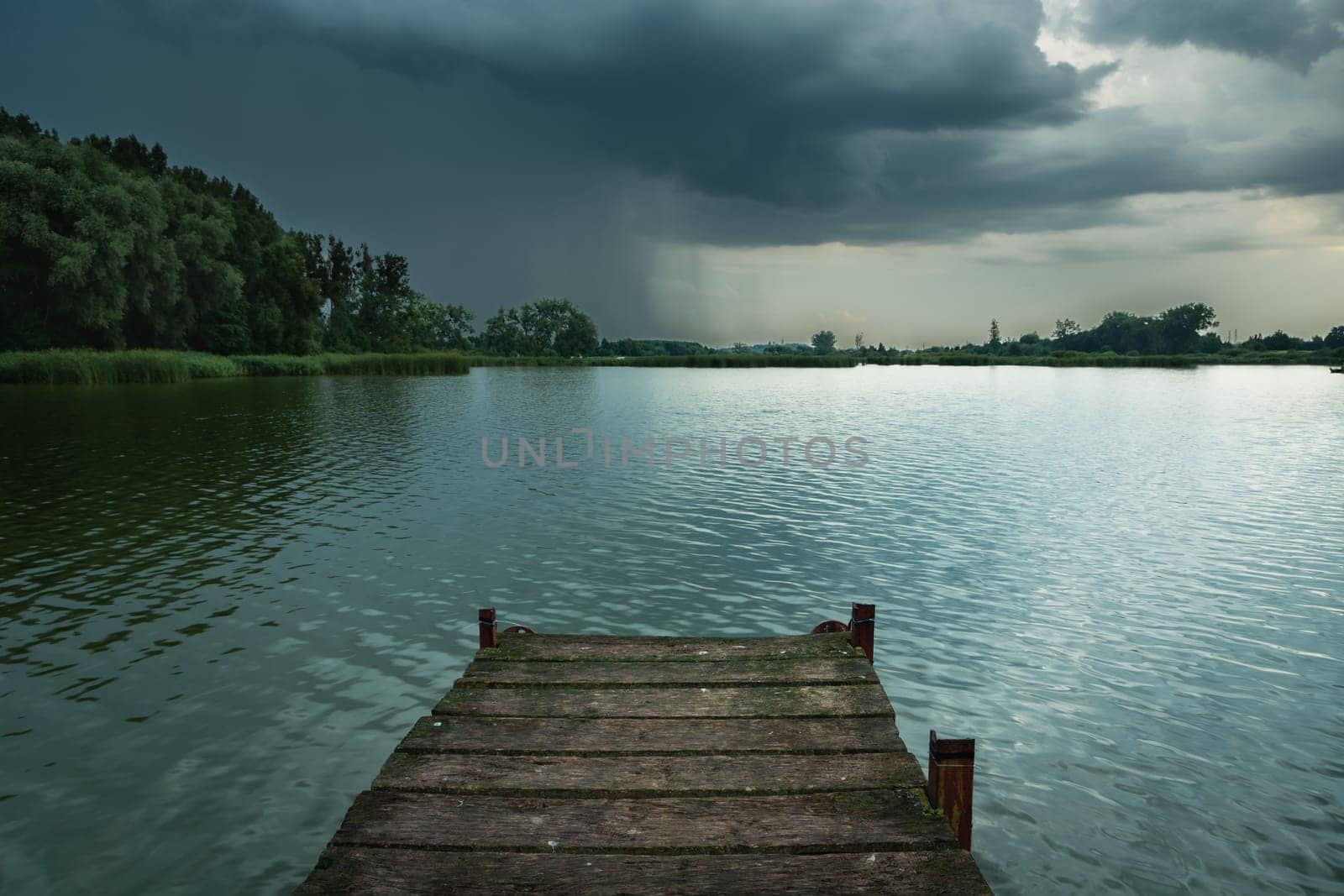 Wooden pier towards the lake and a thundercloud, Stankow, Poland