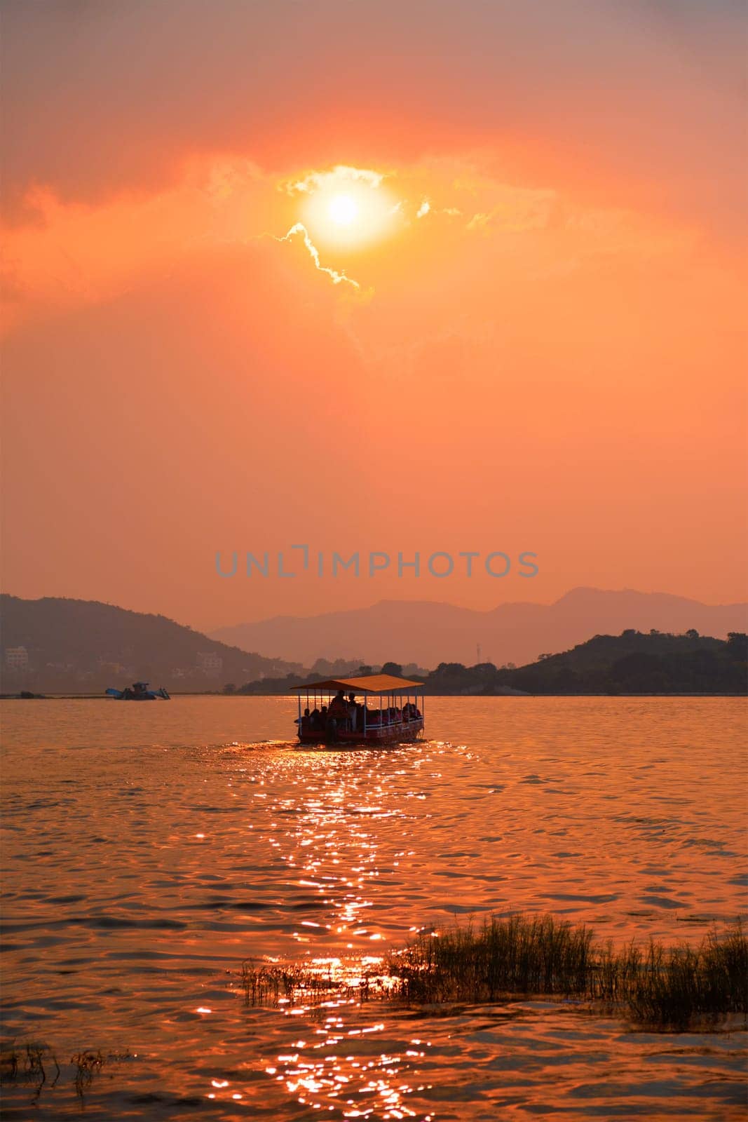 Tourist boat in lake Pichola on sunset. Udaipur, Rajasthan, India