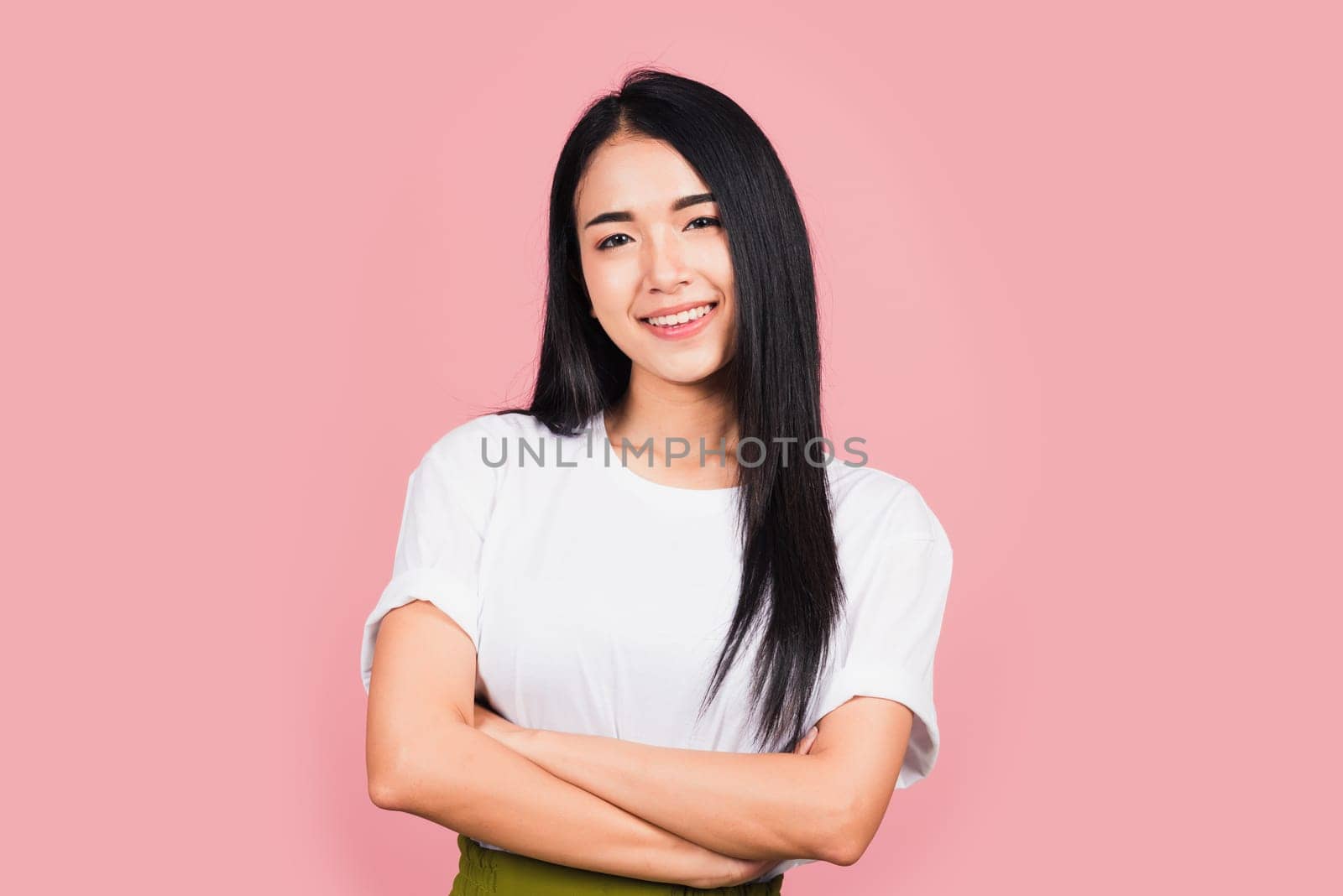 Asian happy portrait beautiful cute young woman standing her smile confidence with crossed arms isolated, studio shot on pink background and copy space, Thai female looking to camera