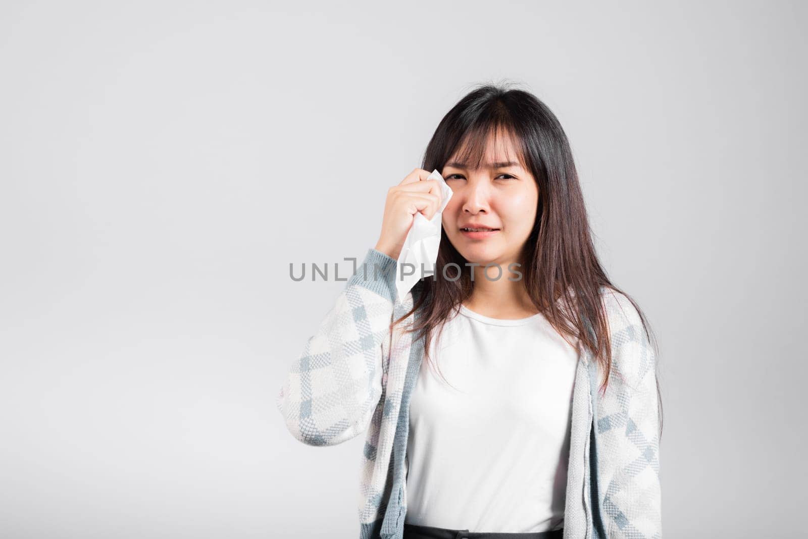 Unhappy woman bad mood her cry wipe mucus with tissue, beautiful young female stress feel sneezing sinus use towel to wipe tear from eyes, studio shot isolated on white background with copy space