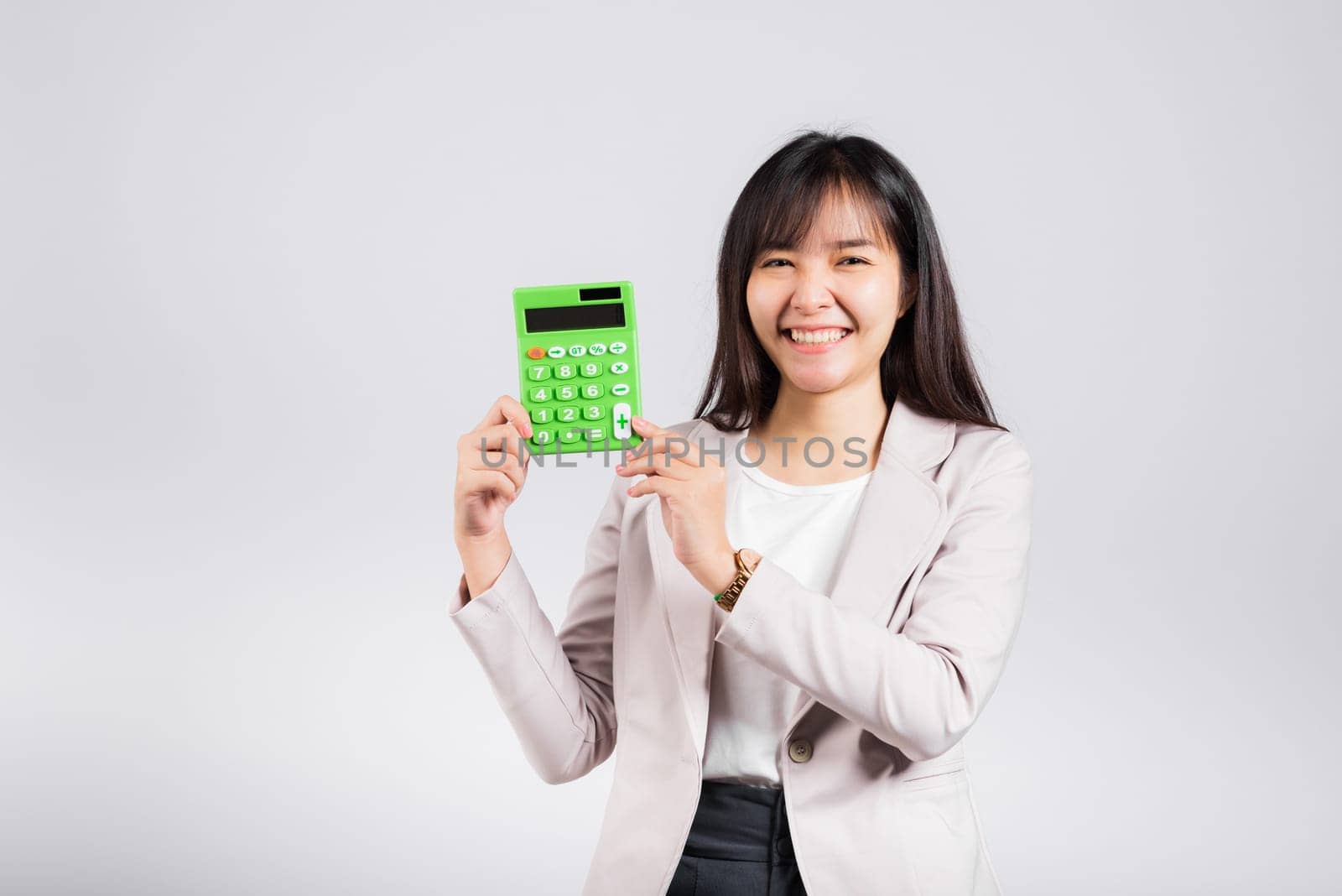 Tax day concept. Woman confident smiling holding electronic calculator, Portrait excited happy Asian young female studio shot isolated on white background, Business Account and finance counting income