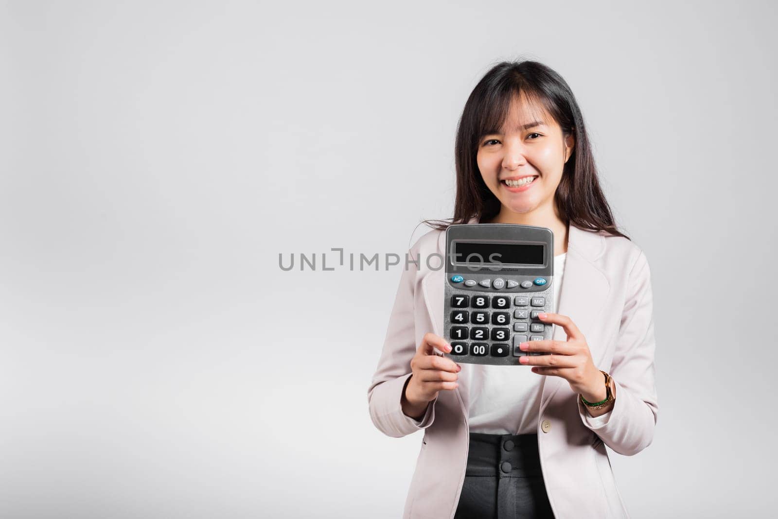 Tax day concept. Woman confident smiling holding electronic calculator, Portrait excited happy Asian young female studio shot isolated on white background, Business Account and finance counting income