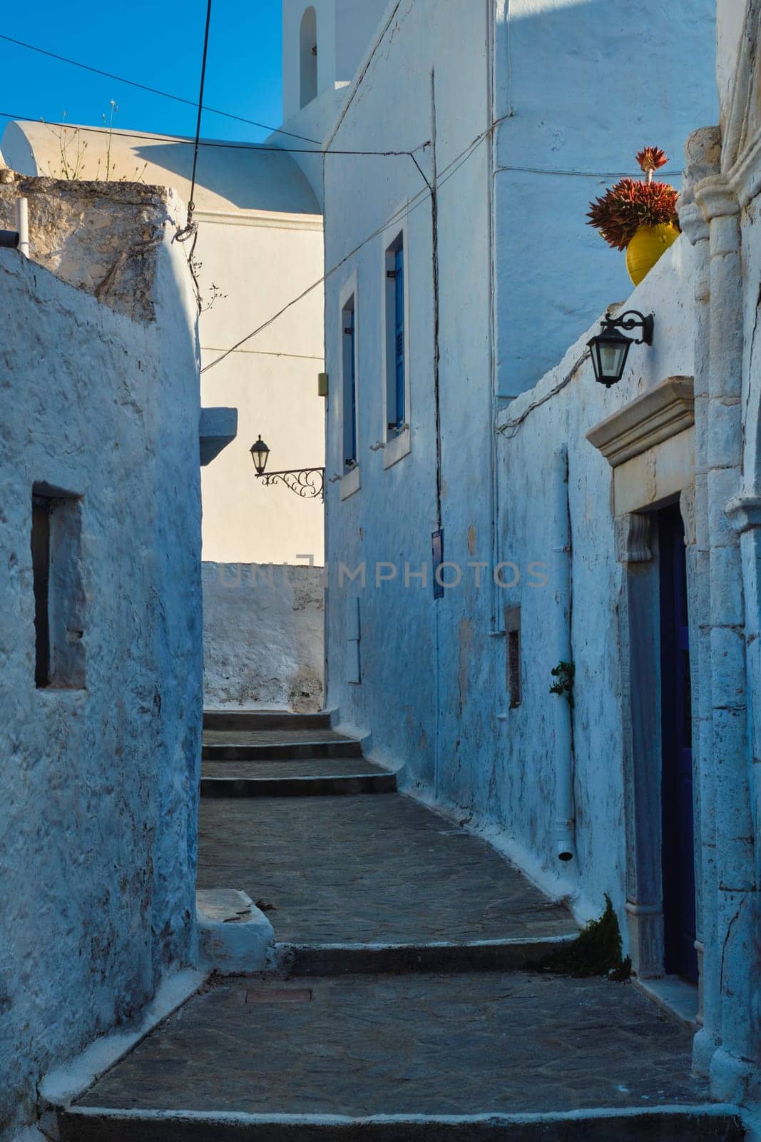 Greek village typical street view with whitewashed houses and stairs. Plaka town, Milos island, Greece