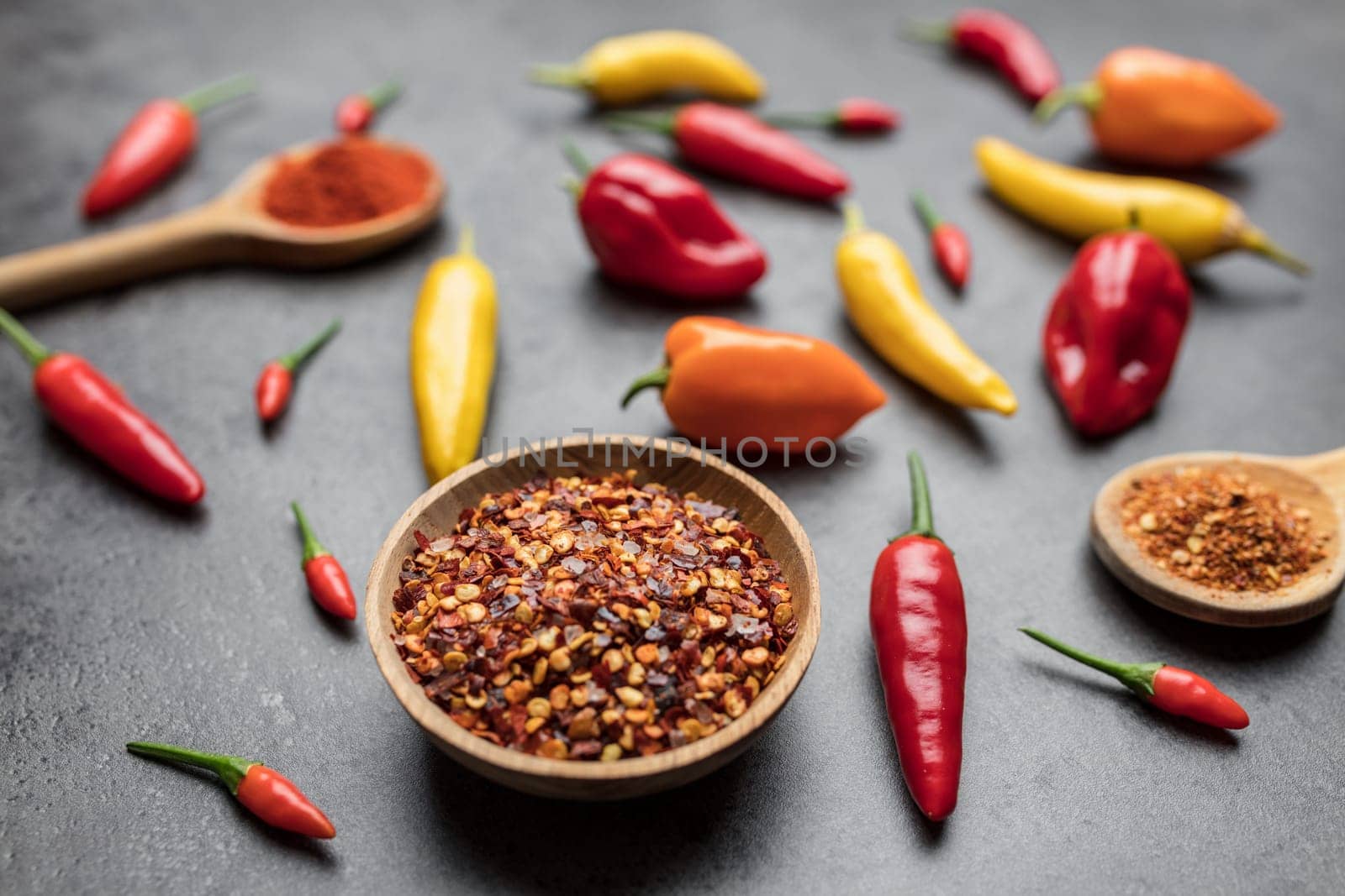 Variety of fresh and dried chili peppers on rustic background