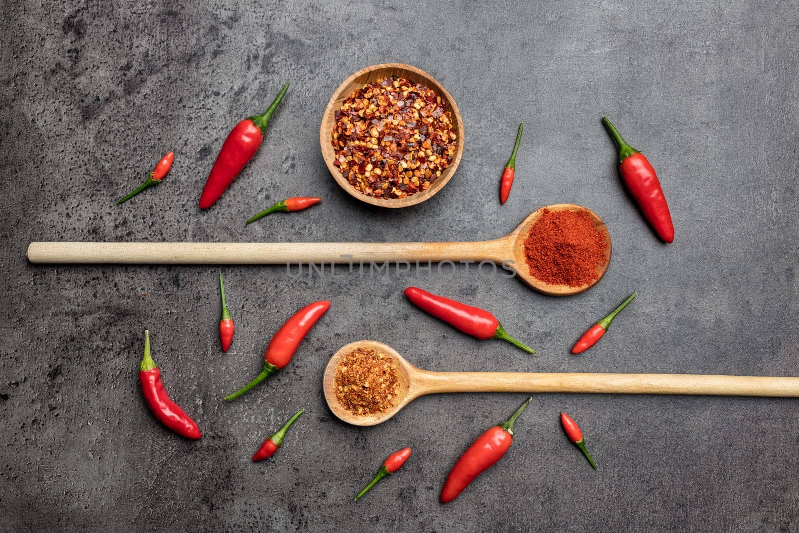 Variety of fresh and dried chili peppers on rustic background