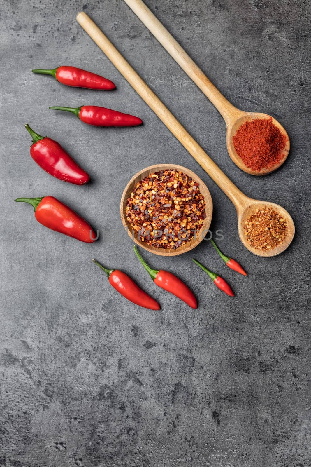 Variety of fresh and dried chili peppers on rustic background