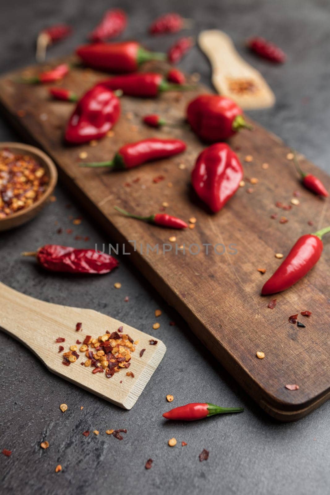 Variety of fresh and dried chili peppers on rustic background