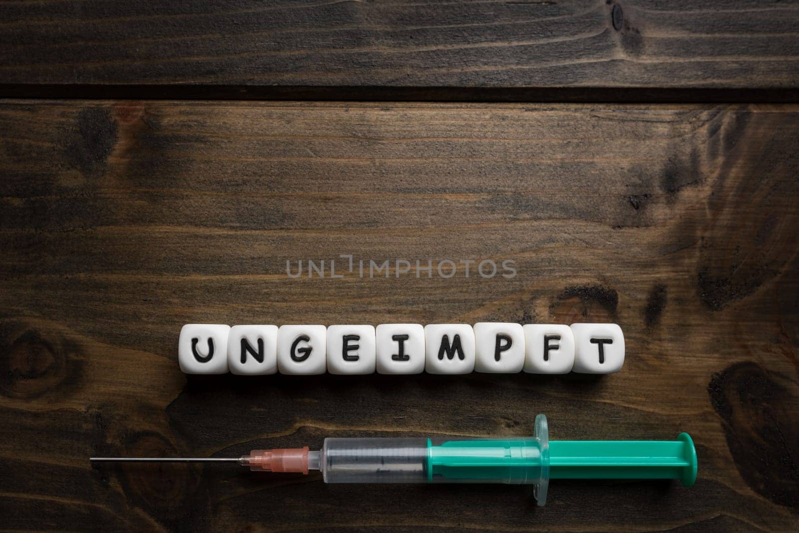 Corona virus Covid-19 vaccine text in German on wooden background