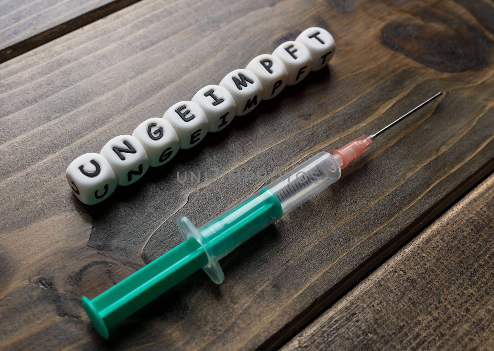Corona virus Covid-19 vaccine text in German on wooden background